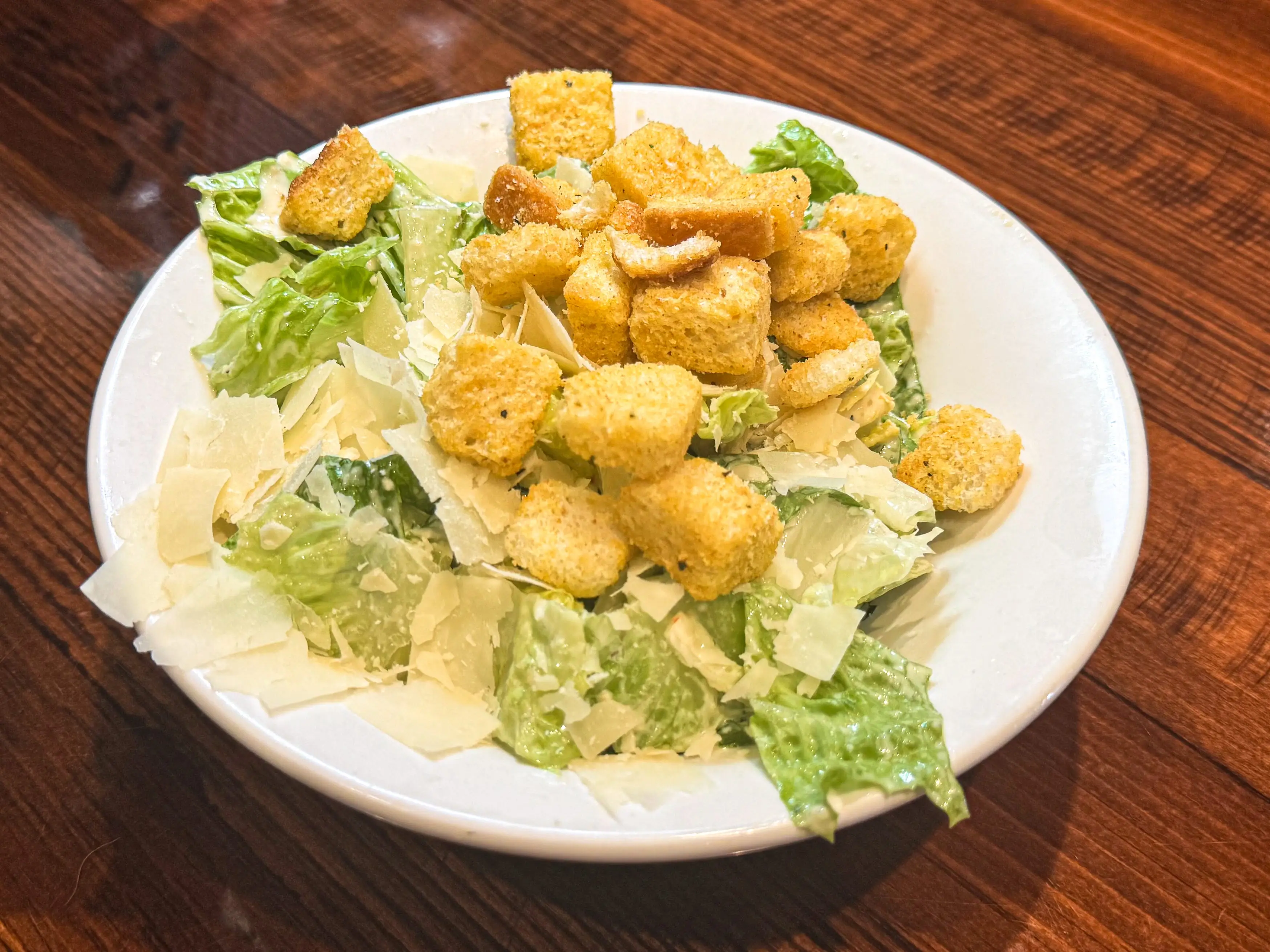 A Caesar salad in a white bowl.