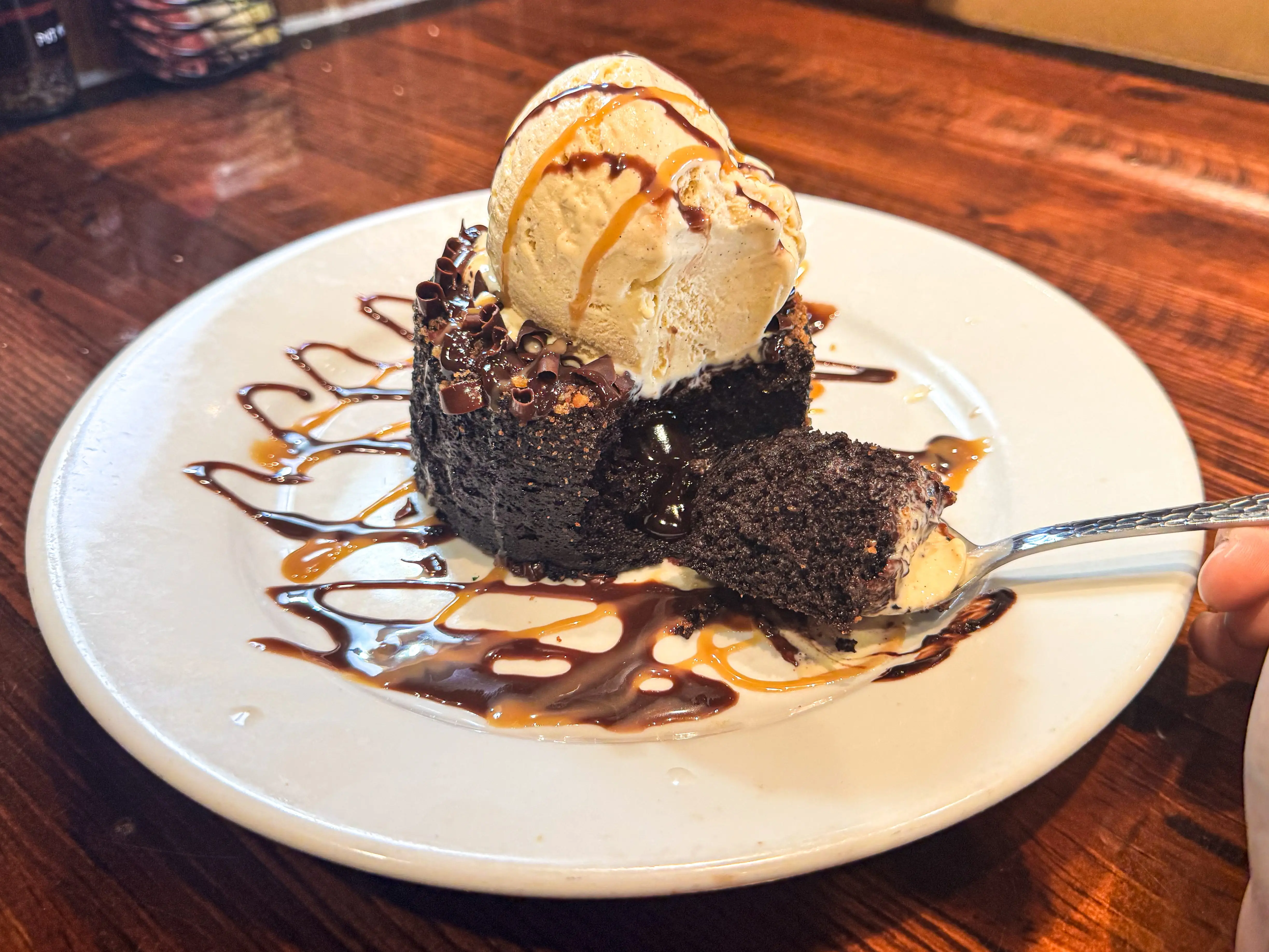 A chocolate lava cake with vanilla ice cream on a white plate.
