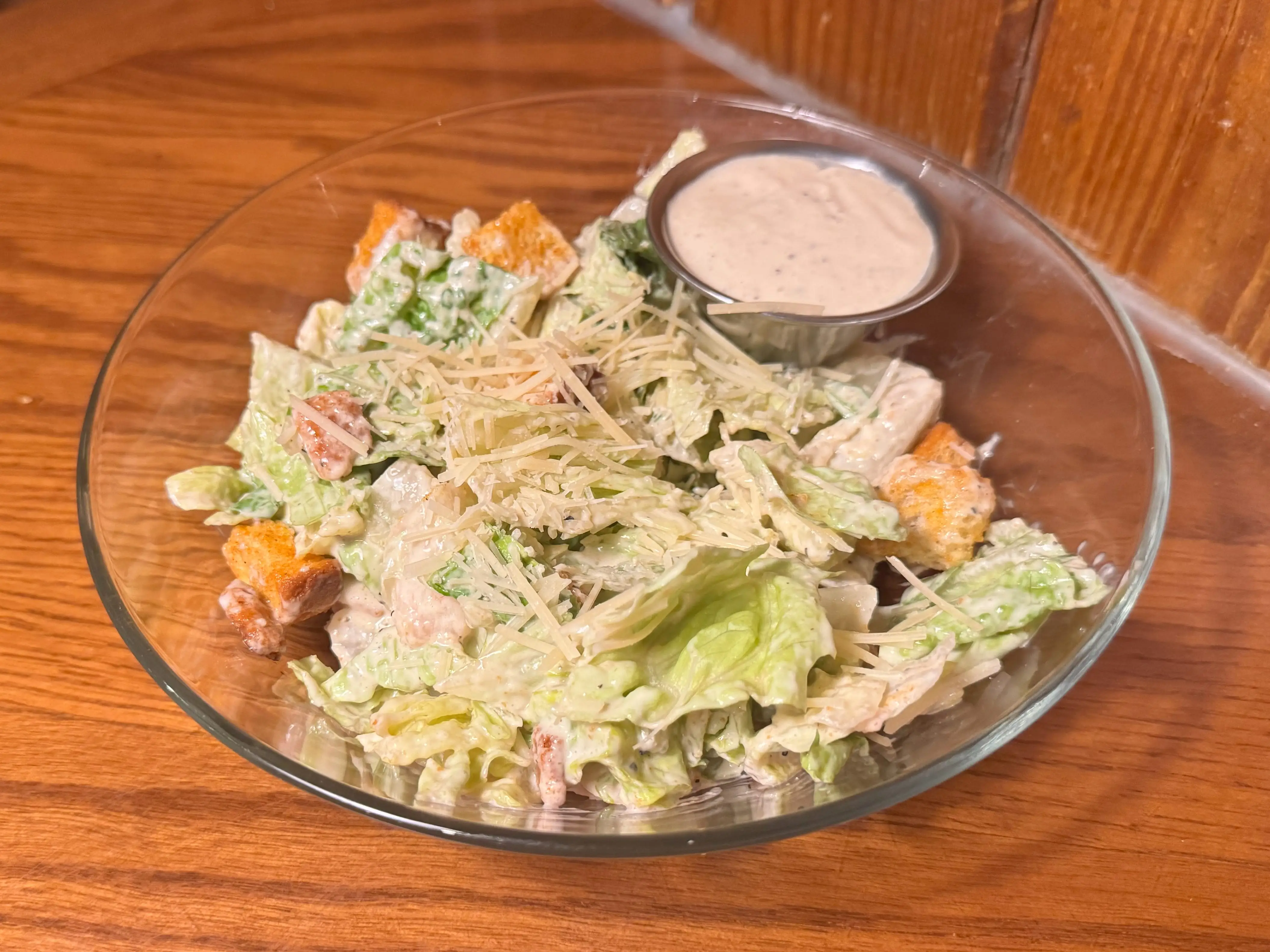 A Caesar salad in a clear bowl.