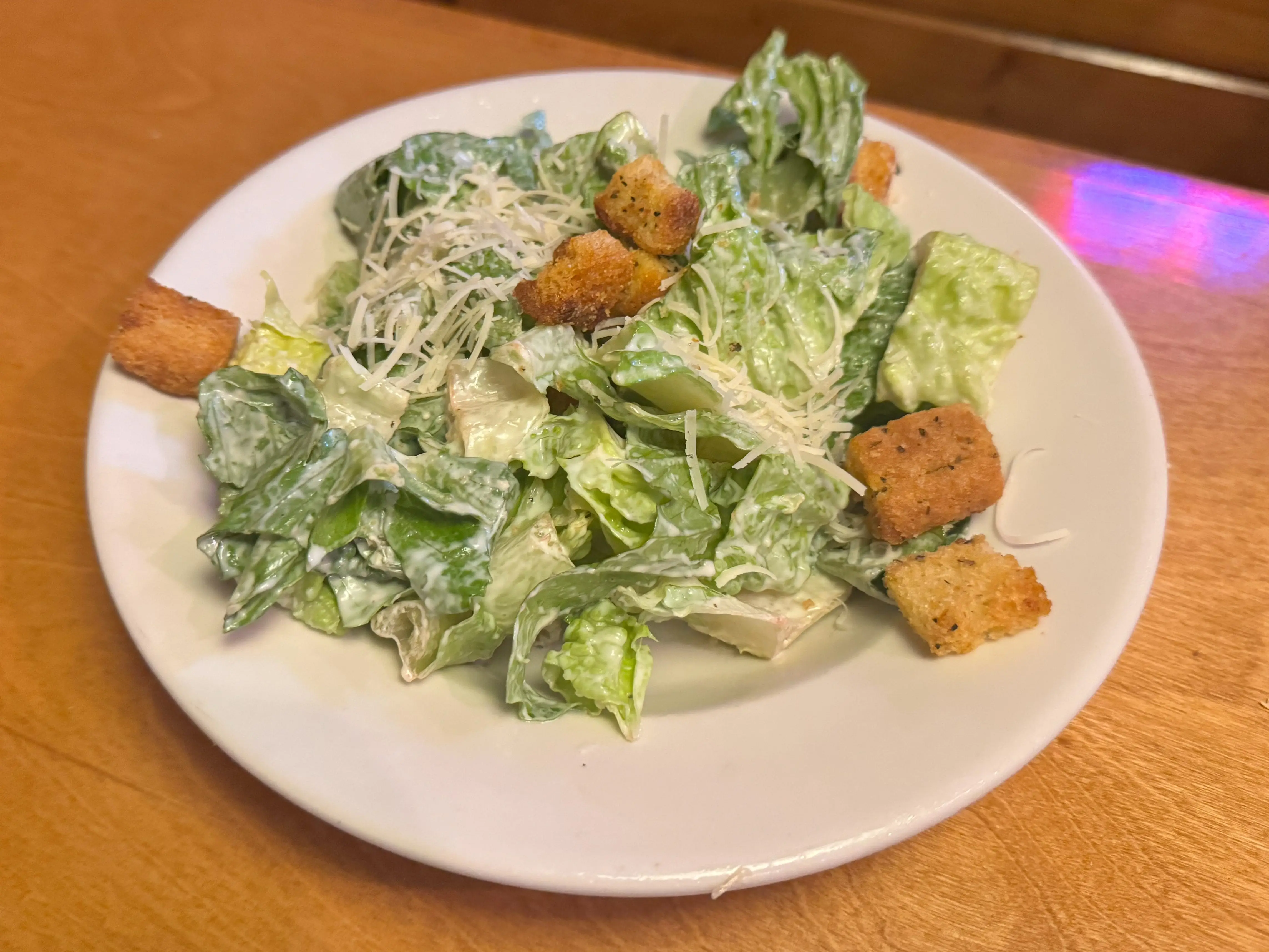 A Caesar salad on a white plate.