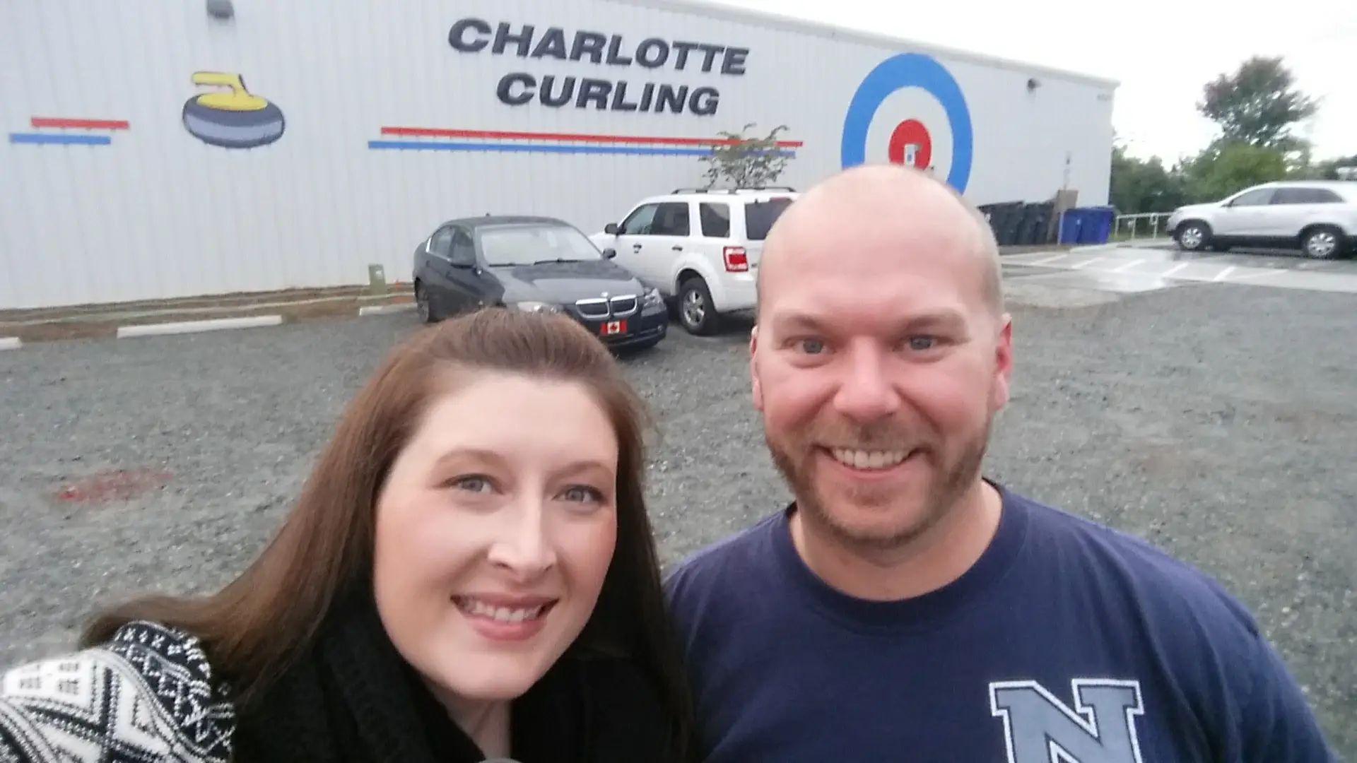Couple smiling in front of Charlotte Curling building