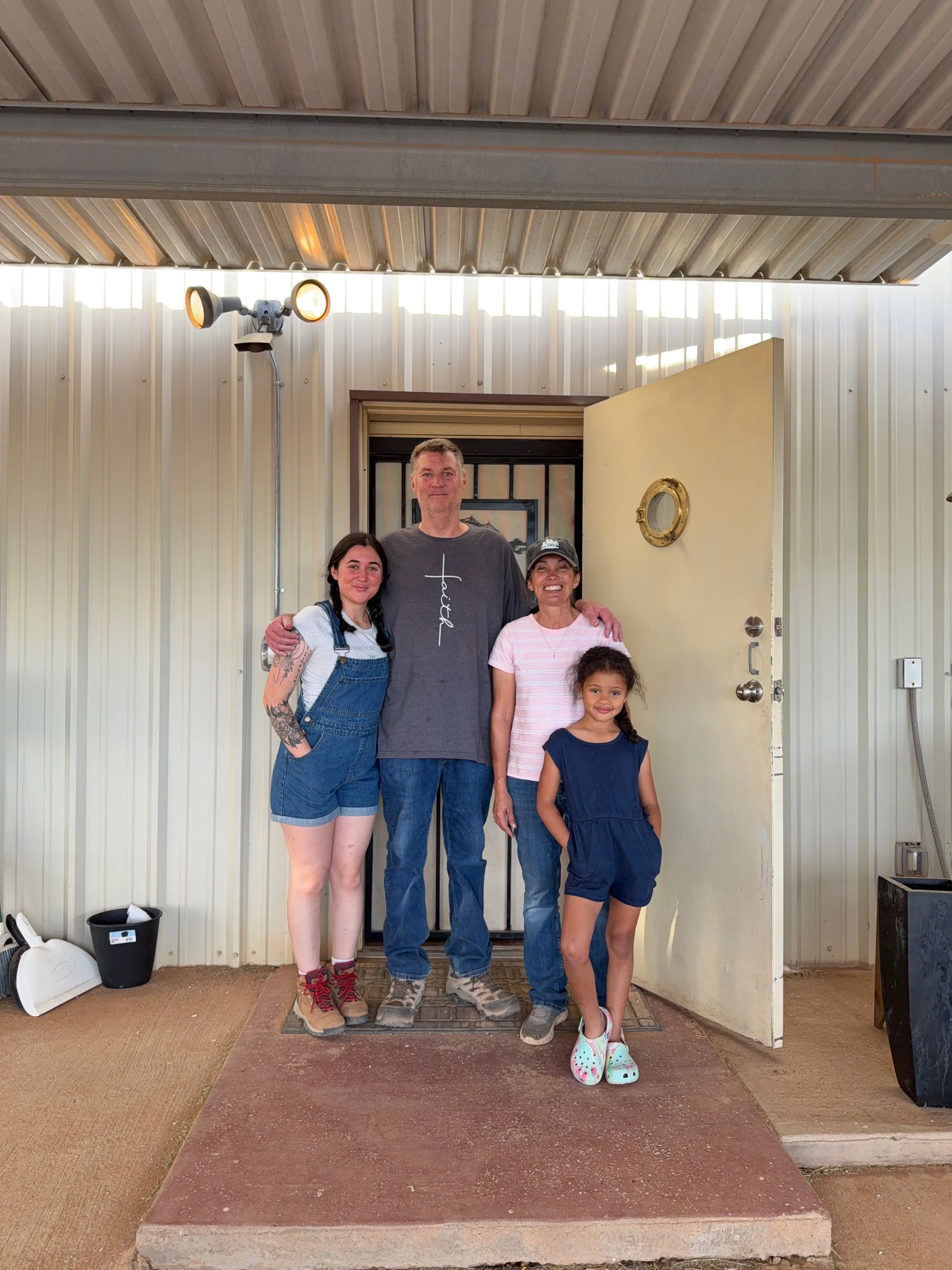 A family stands in front of the entrance to a garage apartment.