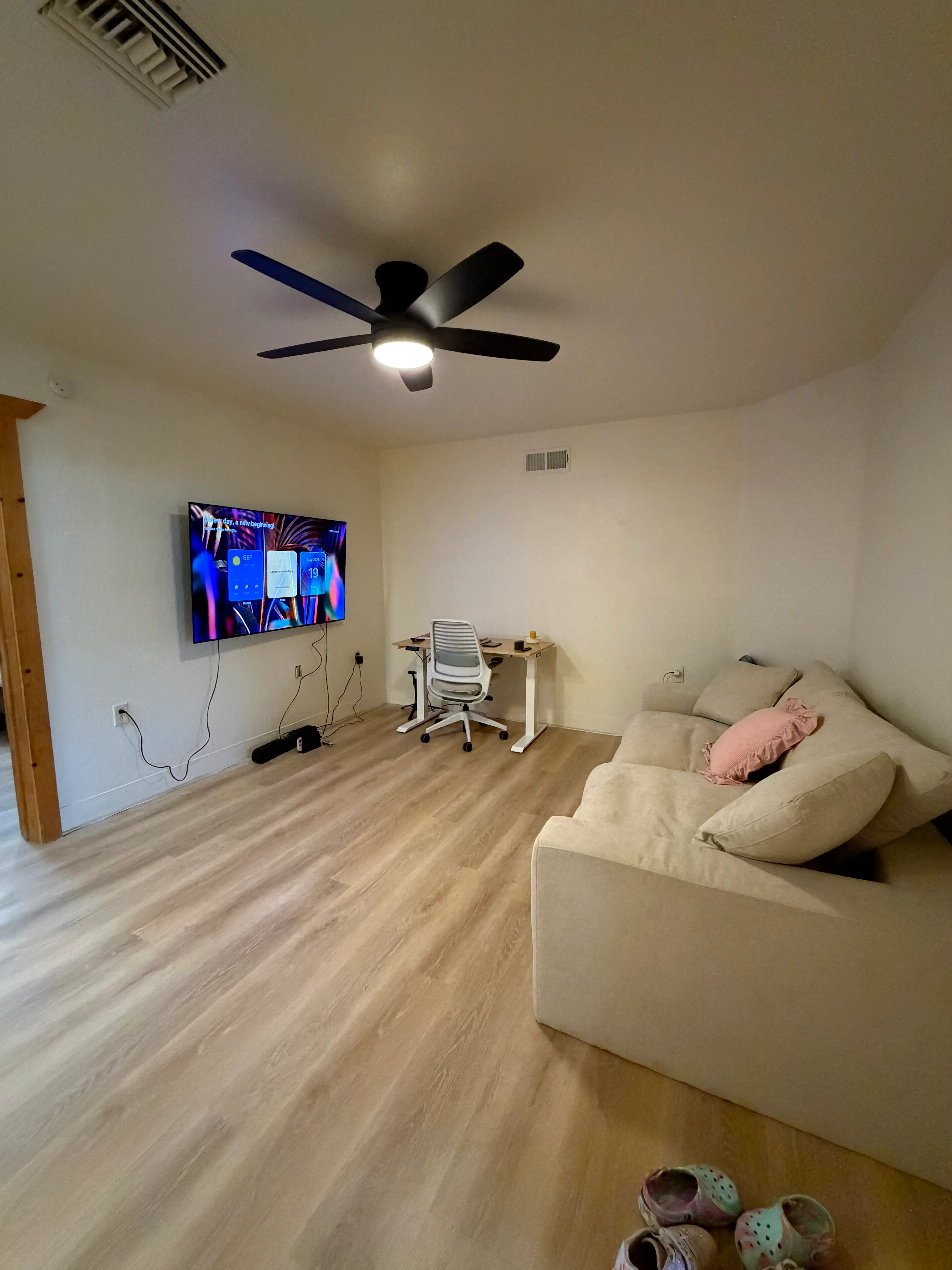 A living room with a tv, couch, and desk.