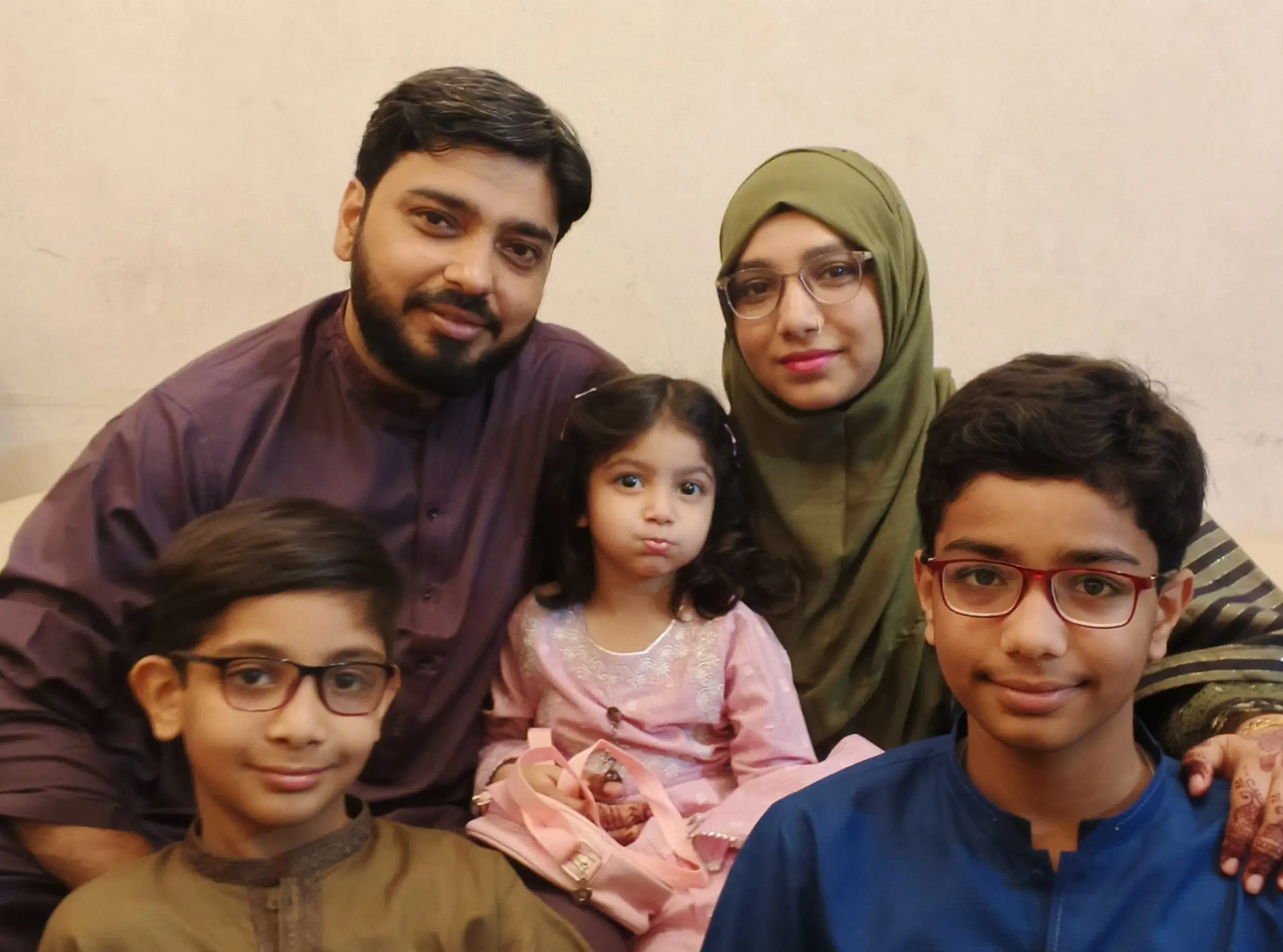 Ariba Mobin (top right) with her husband (left) and three children (front left, right, and center)