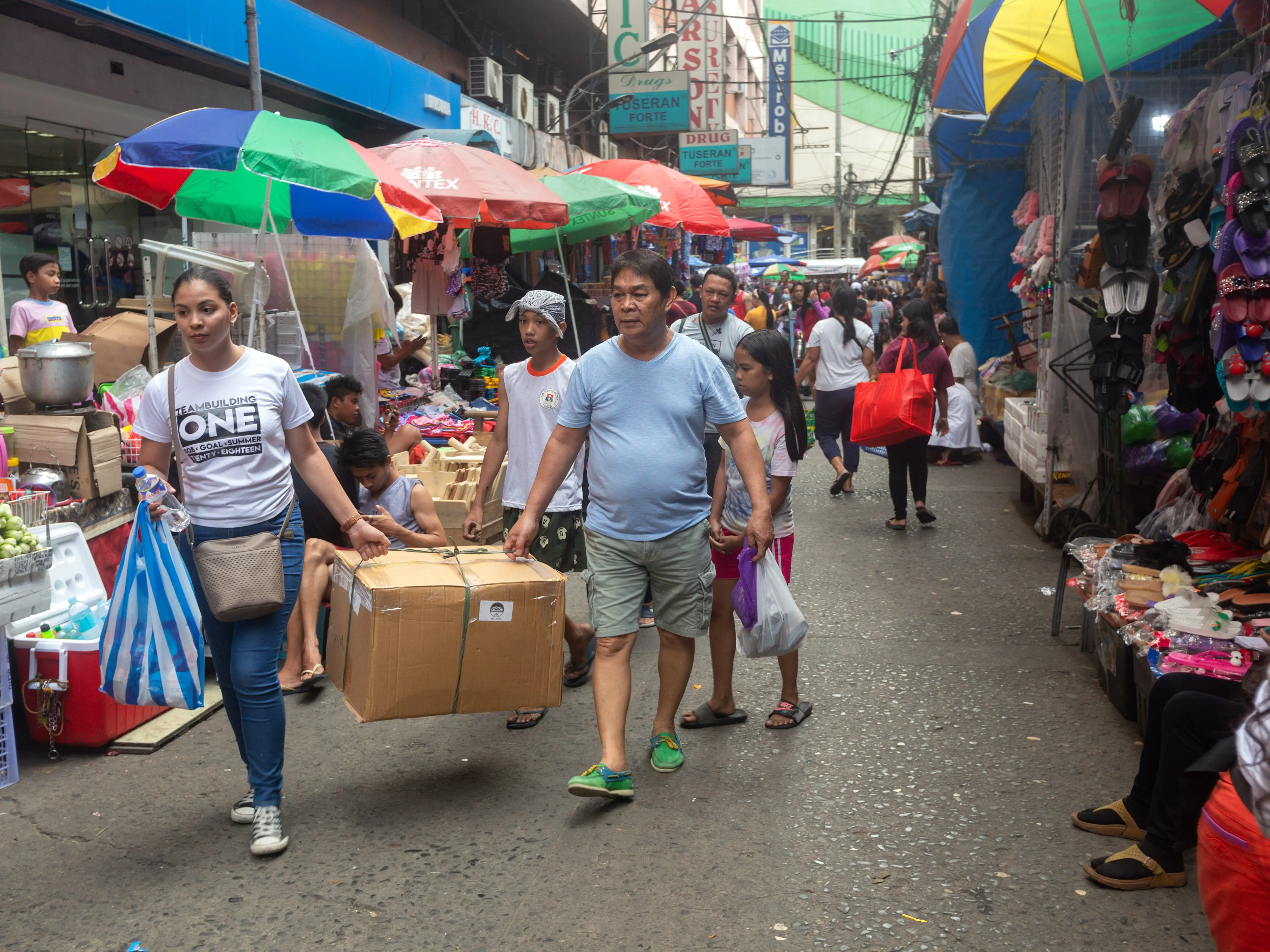 People walk through a Manila, Philippines, street market.