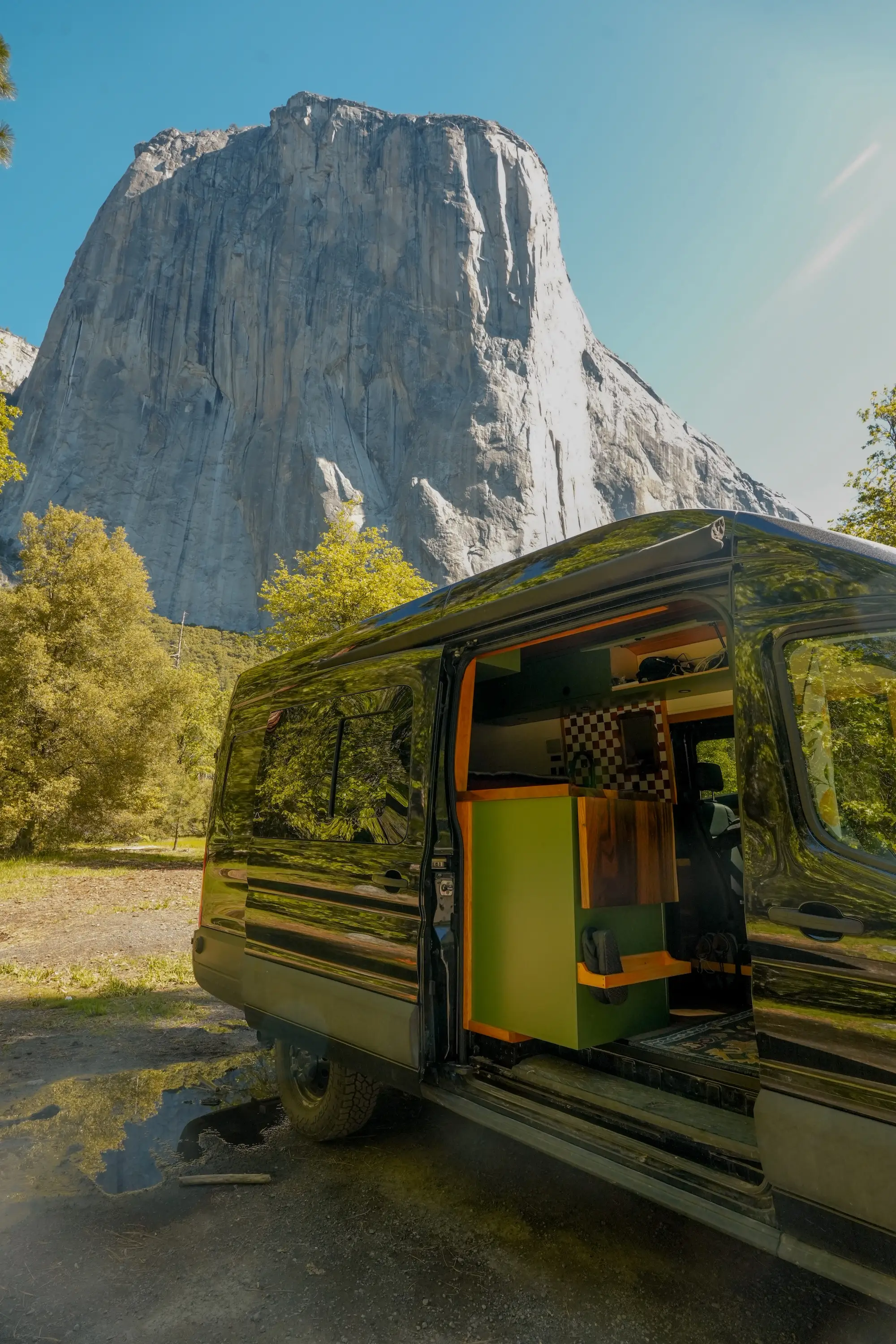 A van with an open doorway sitting in Yosemite National Park.