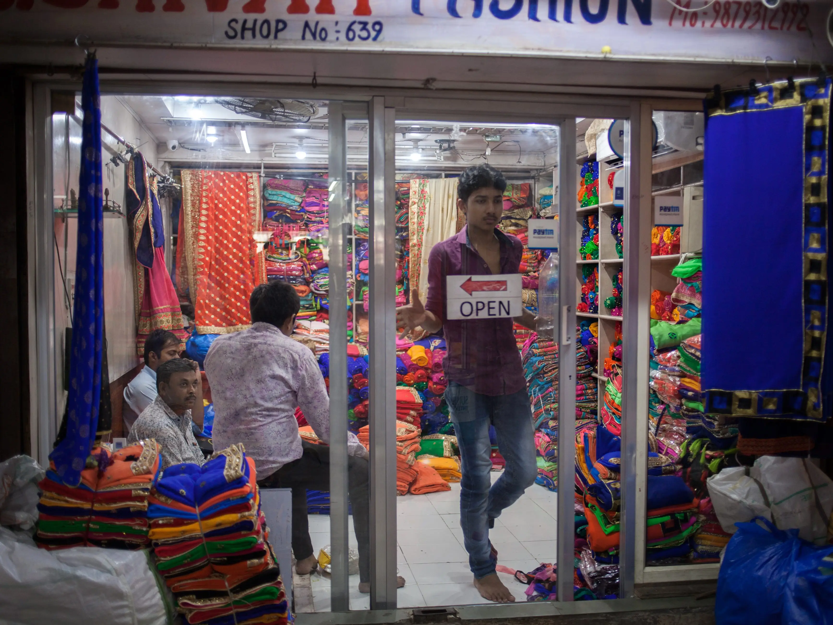 A person leaves a fabric and clothing store in Surat, India.