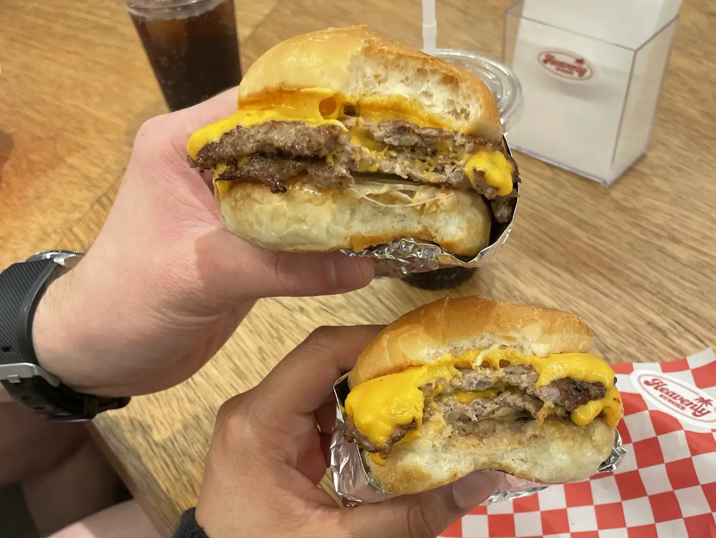 The writer and her husband holding up cheeseburgers in Osaka.