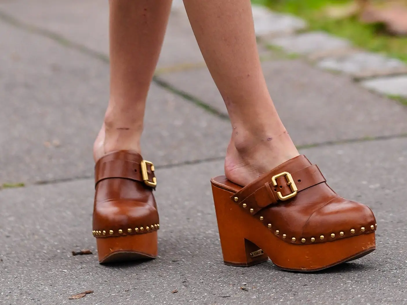 A woman wearing a pair of closed-toed clogs.