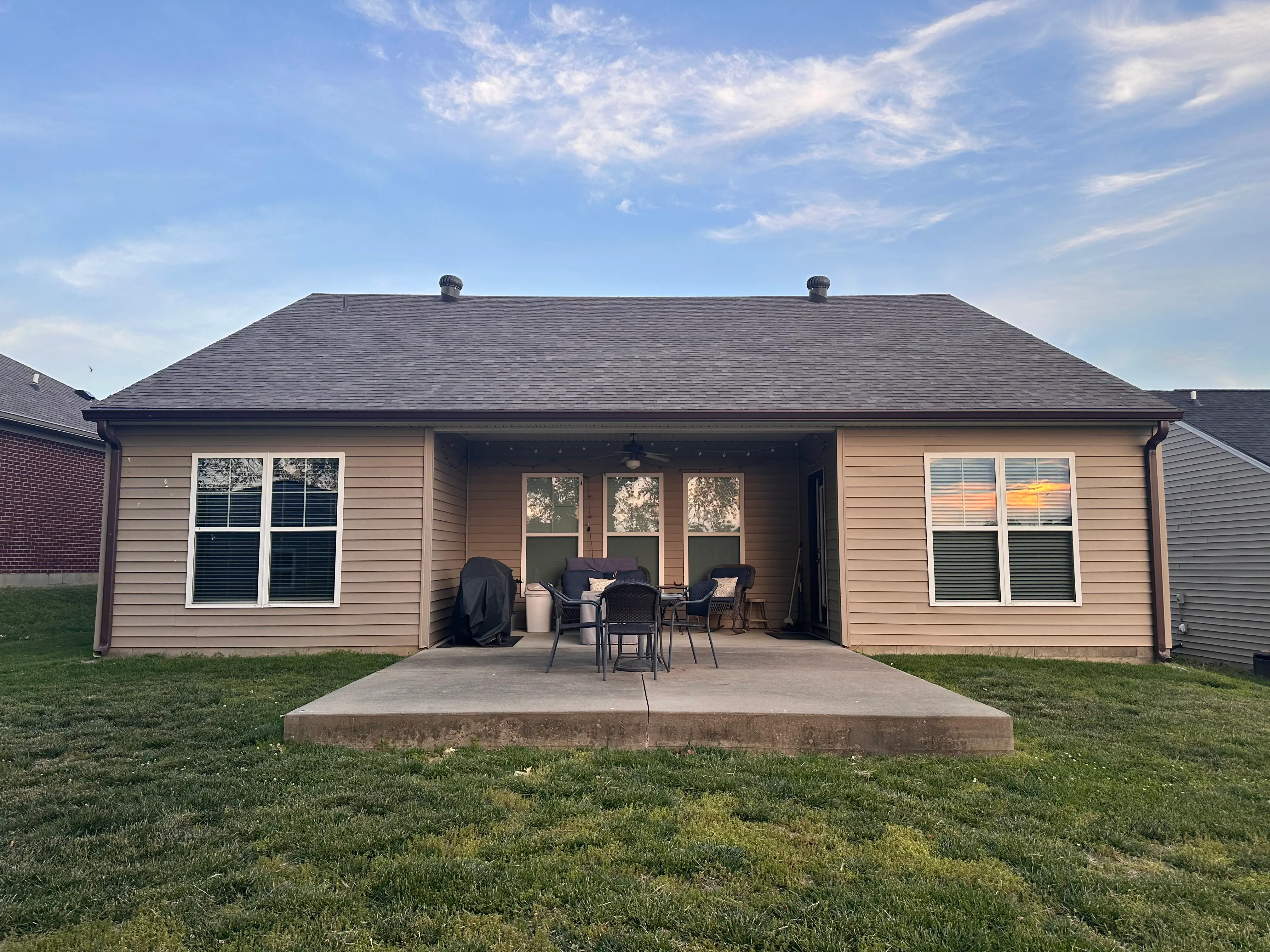 View of back of house with concrete area with chairs