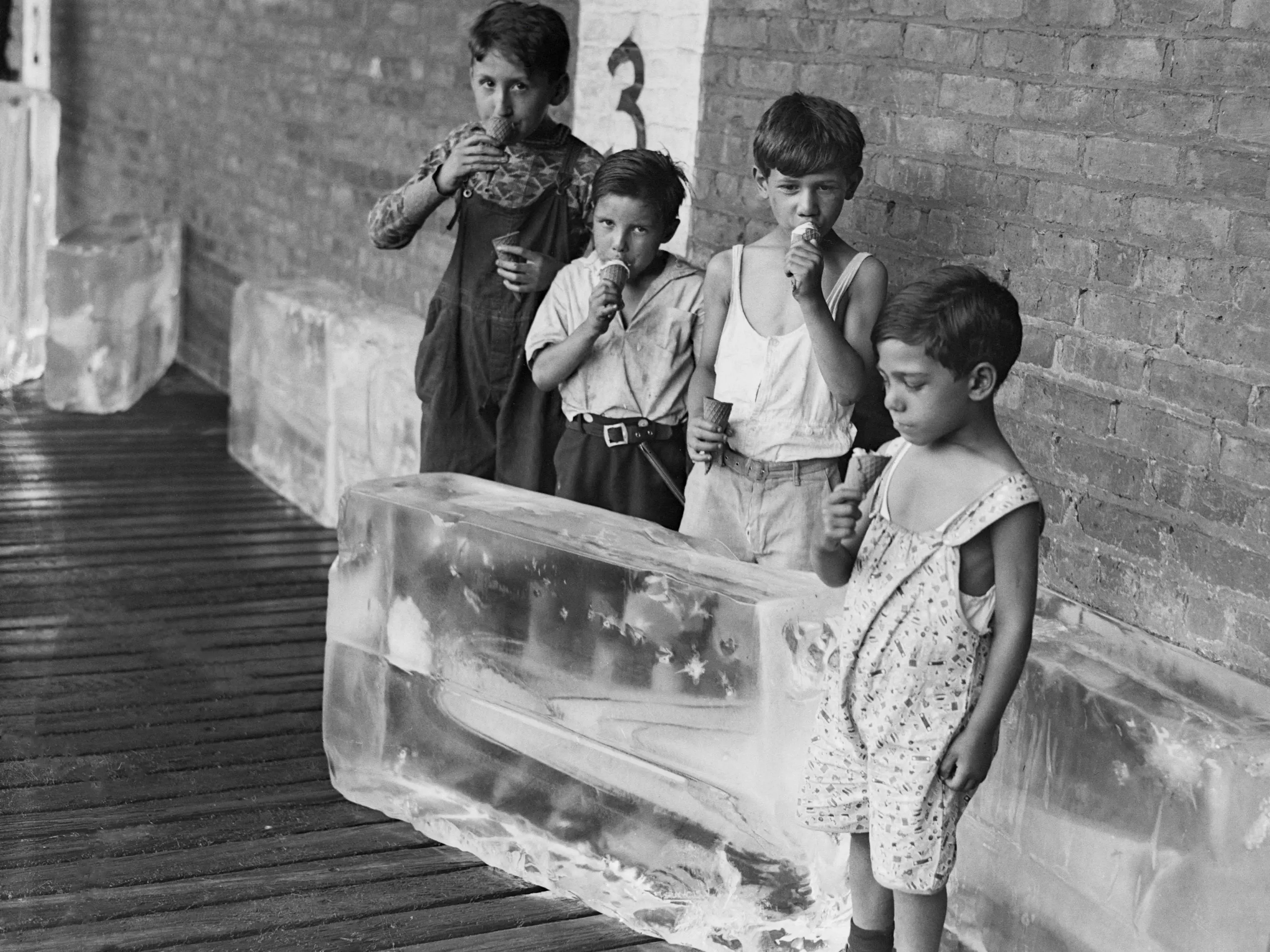 Children eat ice cream next to blocks of ice.