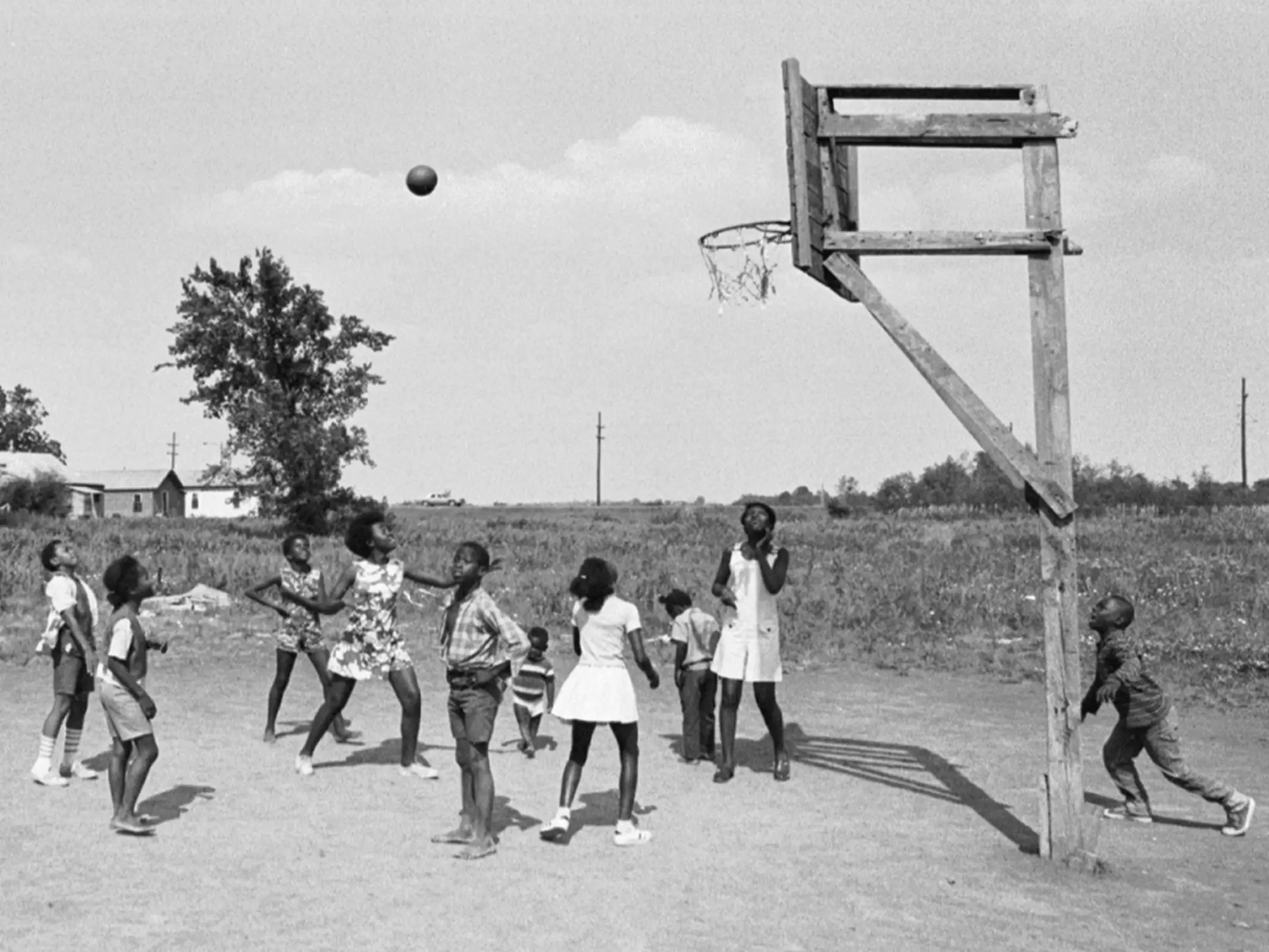Kids playing basketball on a wooden basket.