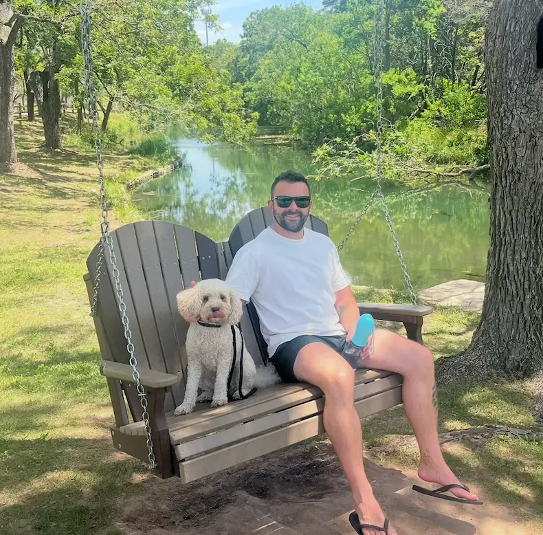 A man sitting on a bench with a dog.