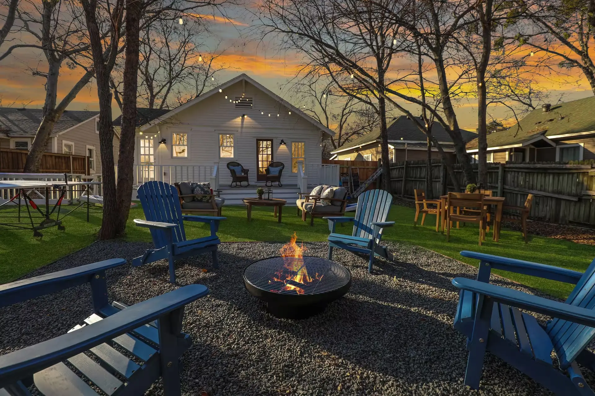 A backyard with a fire pit and ping pong table.