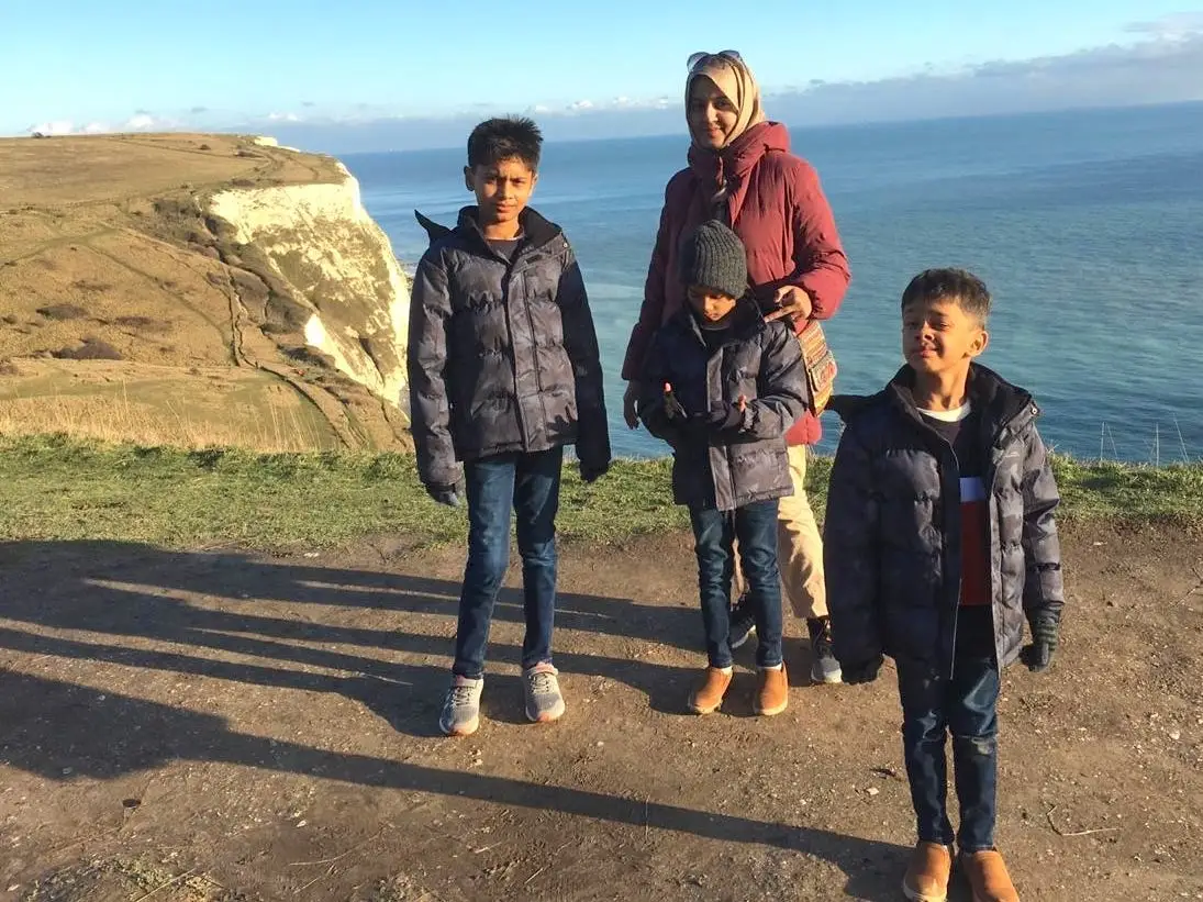 The author with her three children staring on a cliff overlooking water.