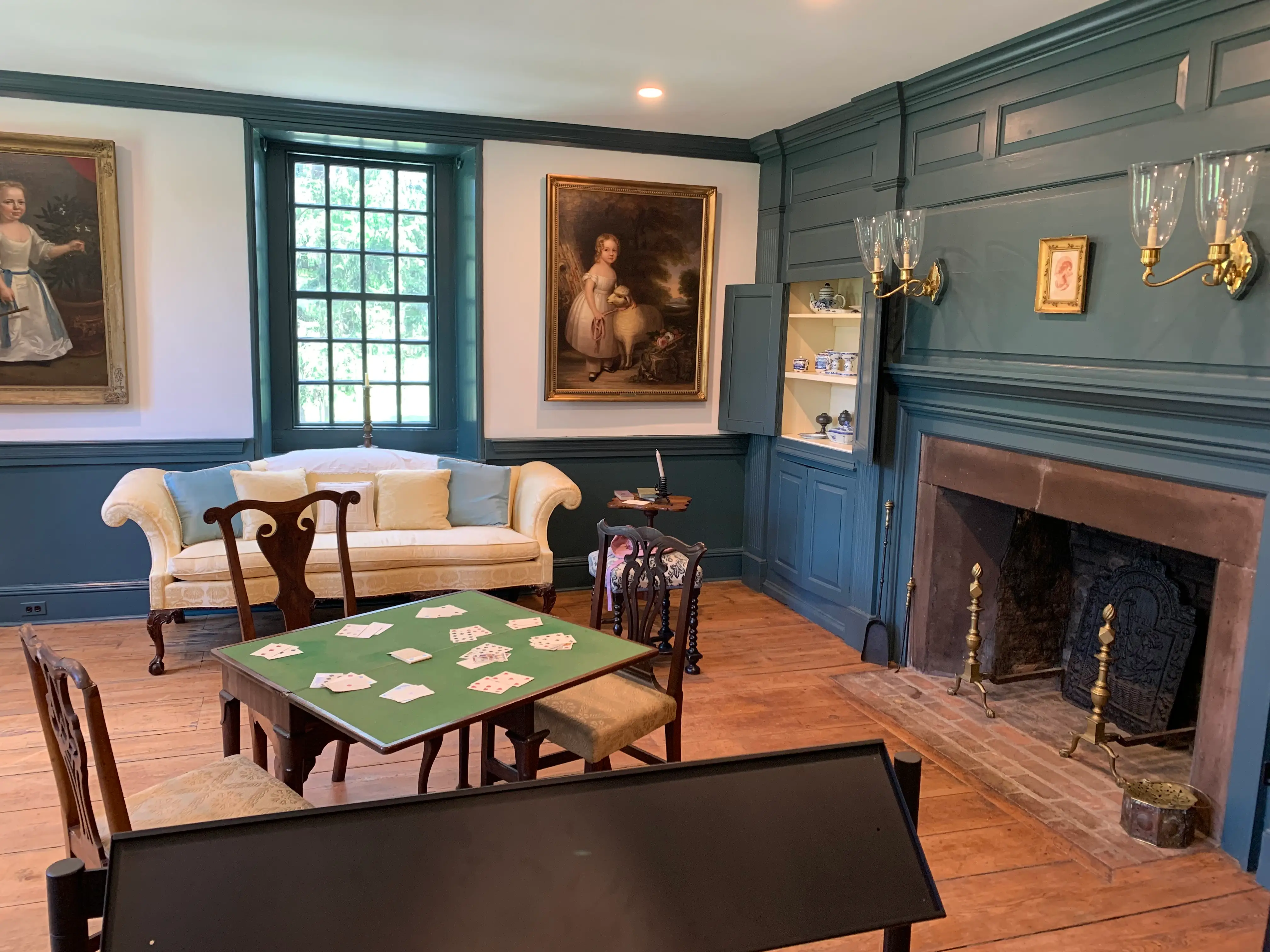 Cards on a table next to a couch and fireplace in the parlor room