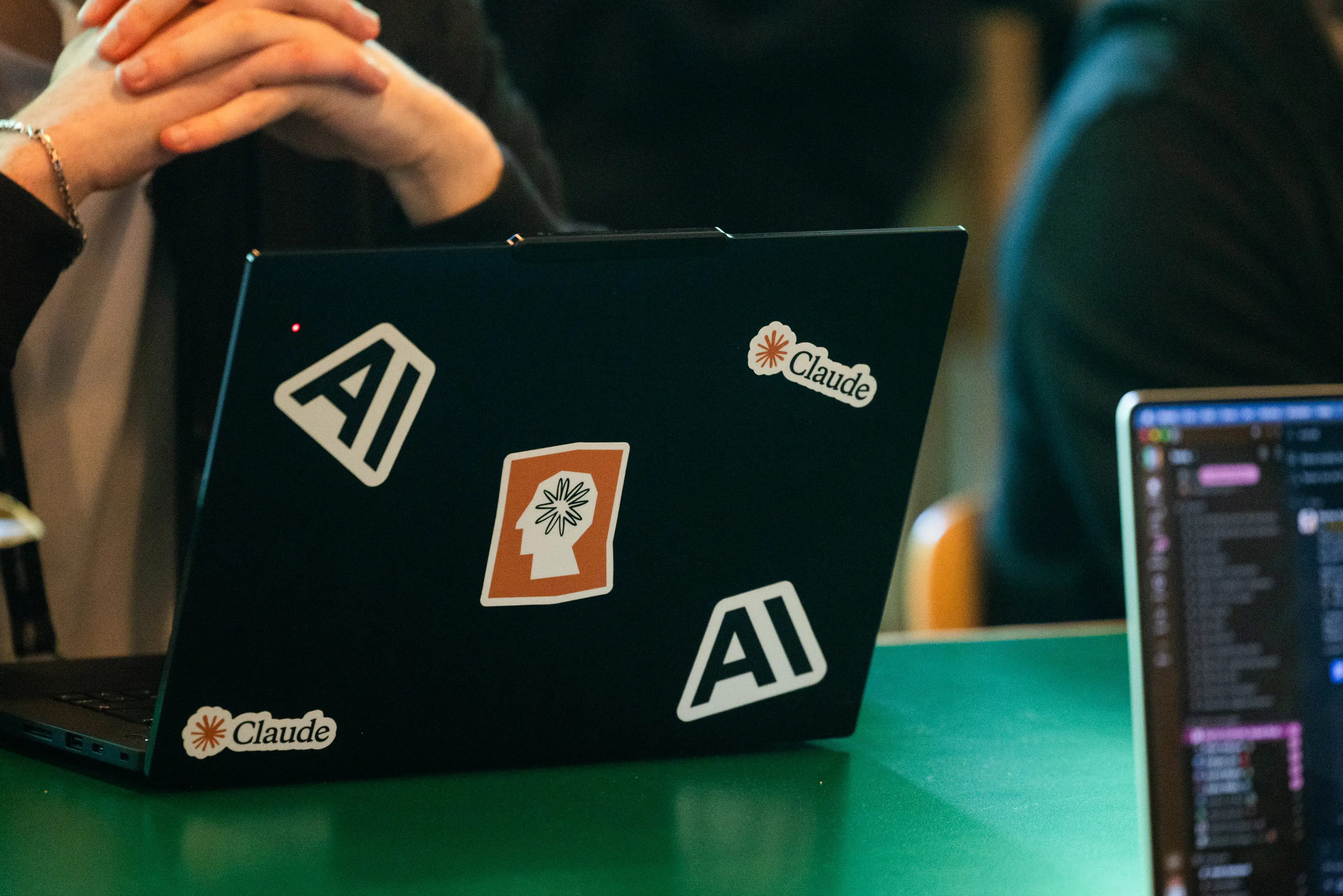 A laptop with Claude Code AI stickers.