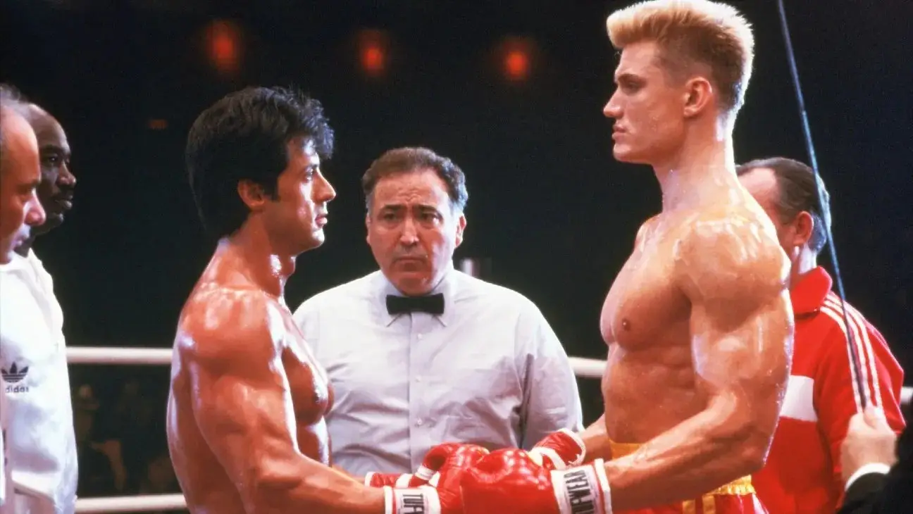 Sylvester Stallone and Dolph Lundgren touching boxing gloves