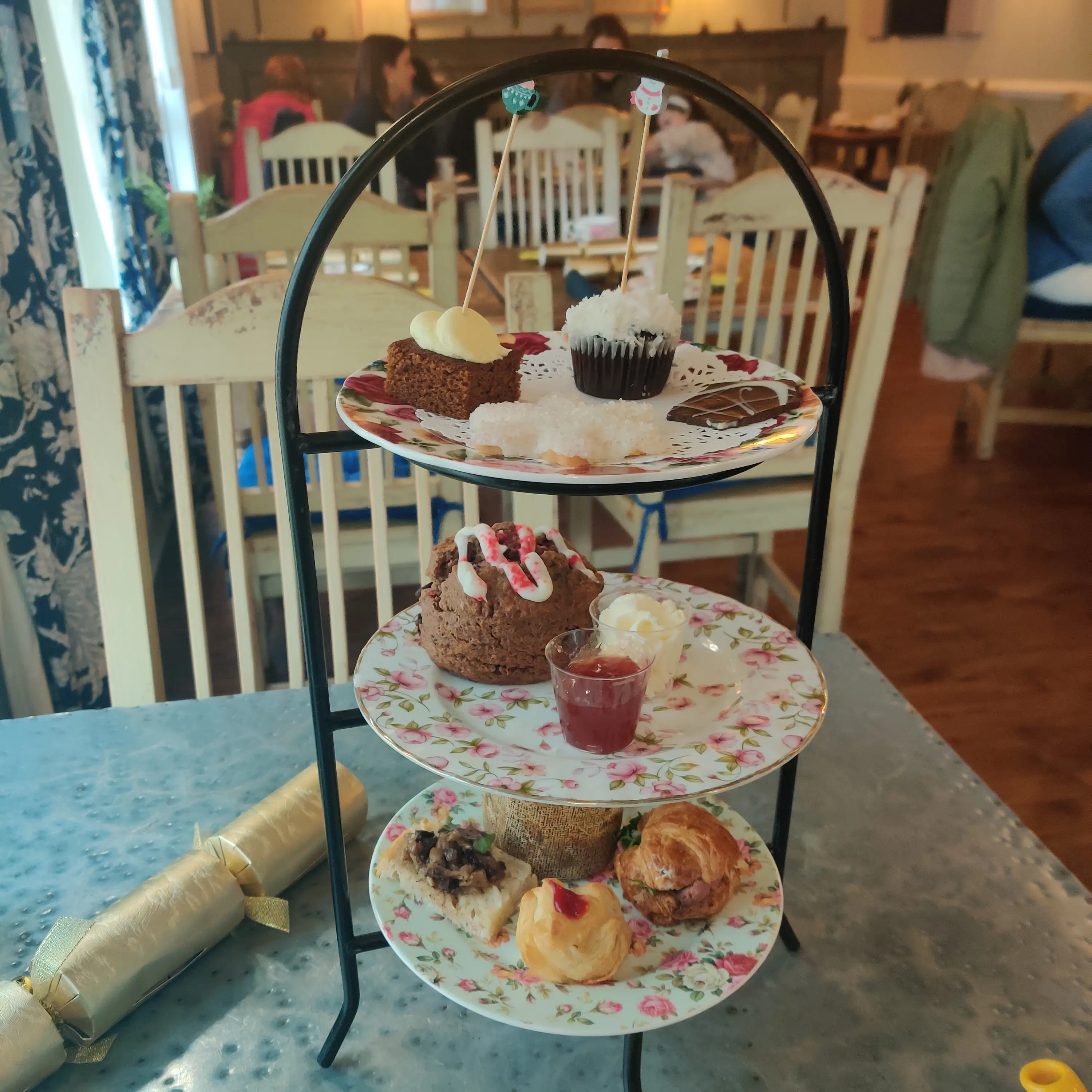A stack of three plates with sweets and scones at afternoon tea on the author's birthday.