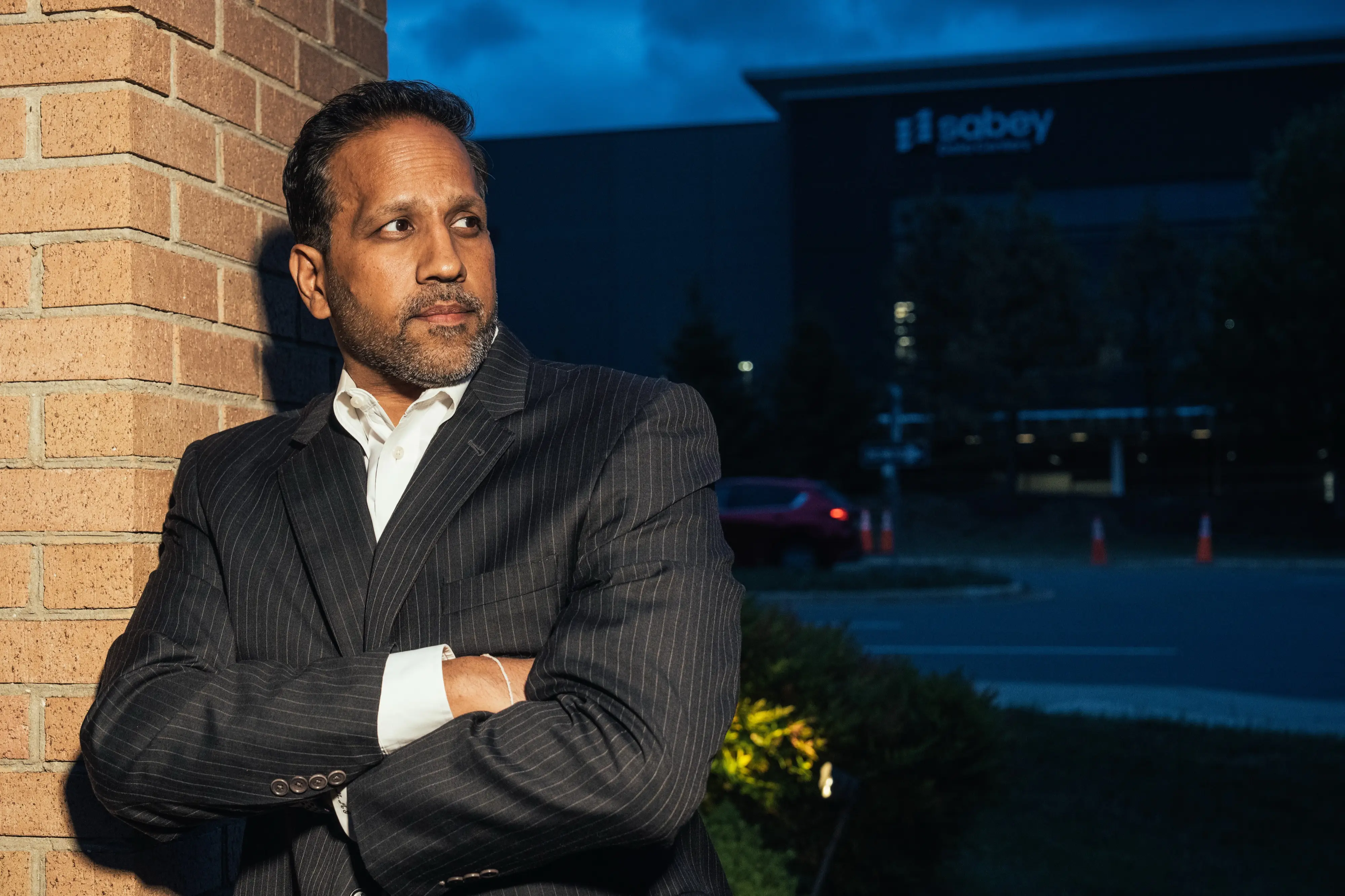 Mital Gandhi poses for a photo in front of a data center, near The Regency, the community where he lives in Ashburn, Virginia in the heart of Data Center Alley.