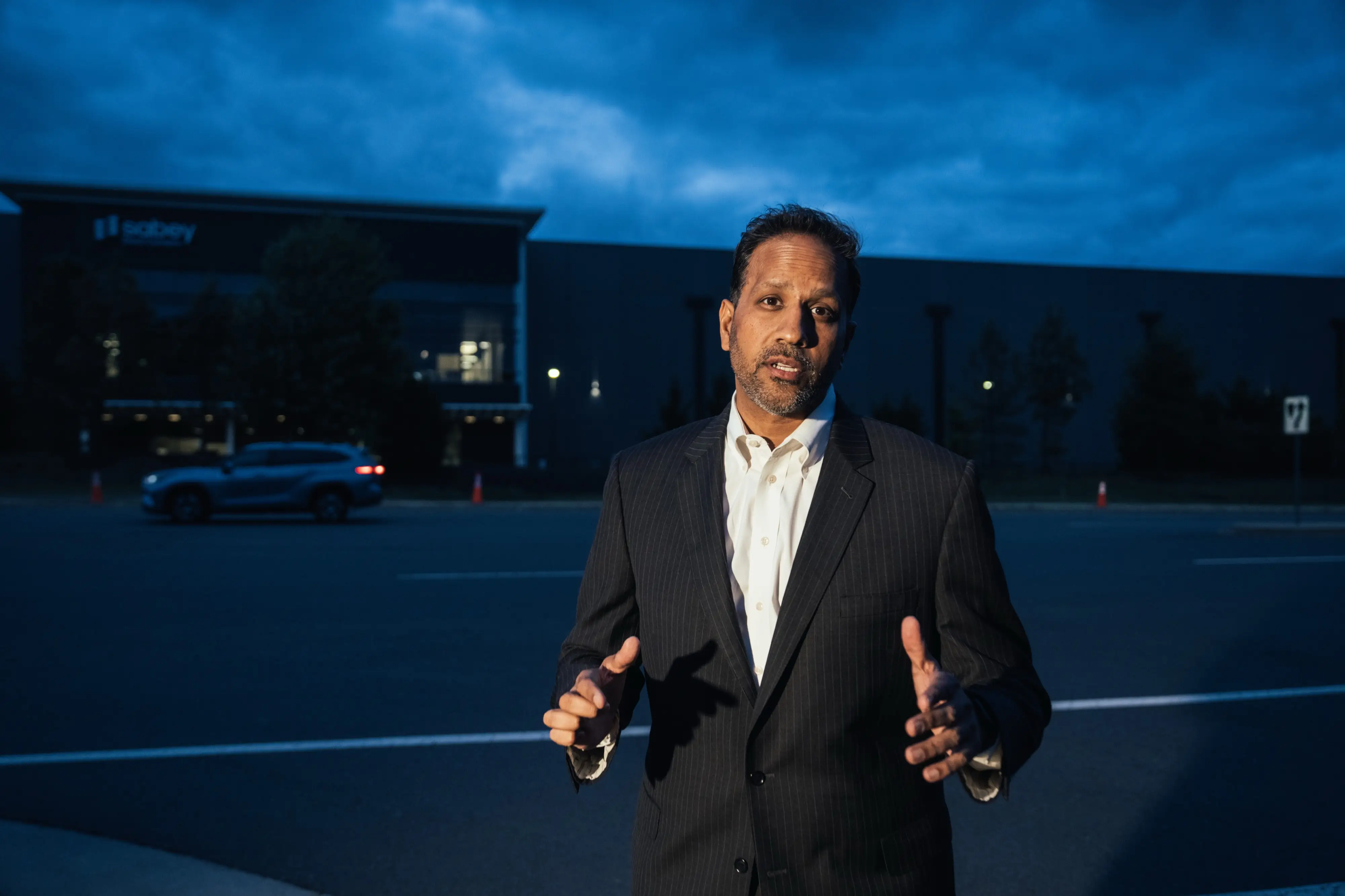 Mital Gandhi poses for a photo in front of a data center, near The Regency, the community where he lives in Ashburn, Virginia in the heart of Data Center Alley.