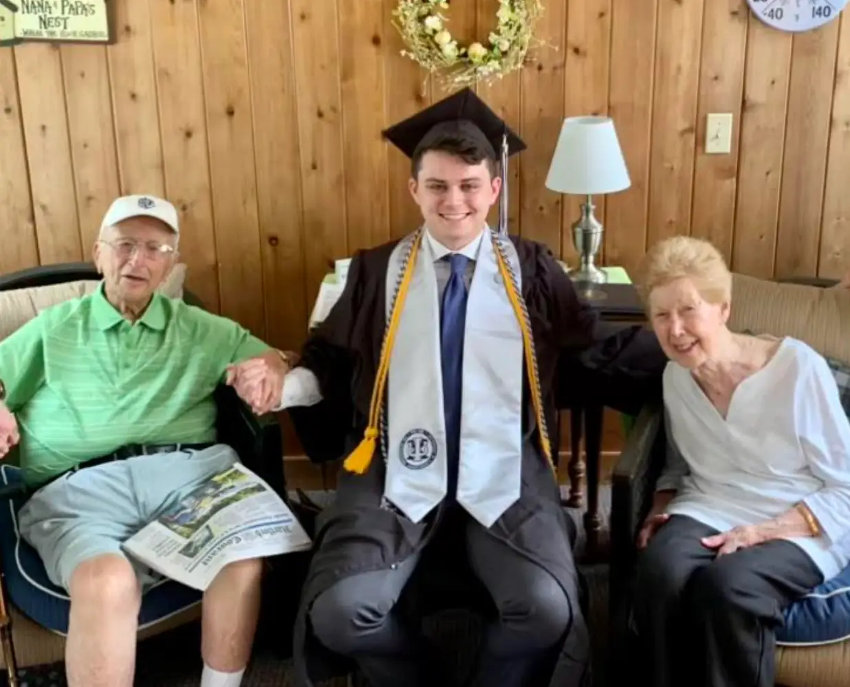 teddy rainvile with his grandparents on graduation day