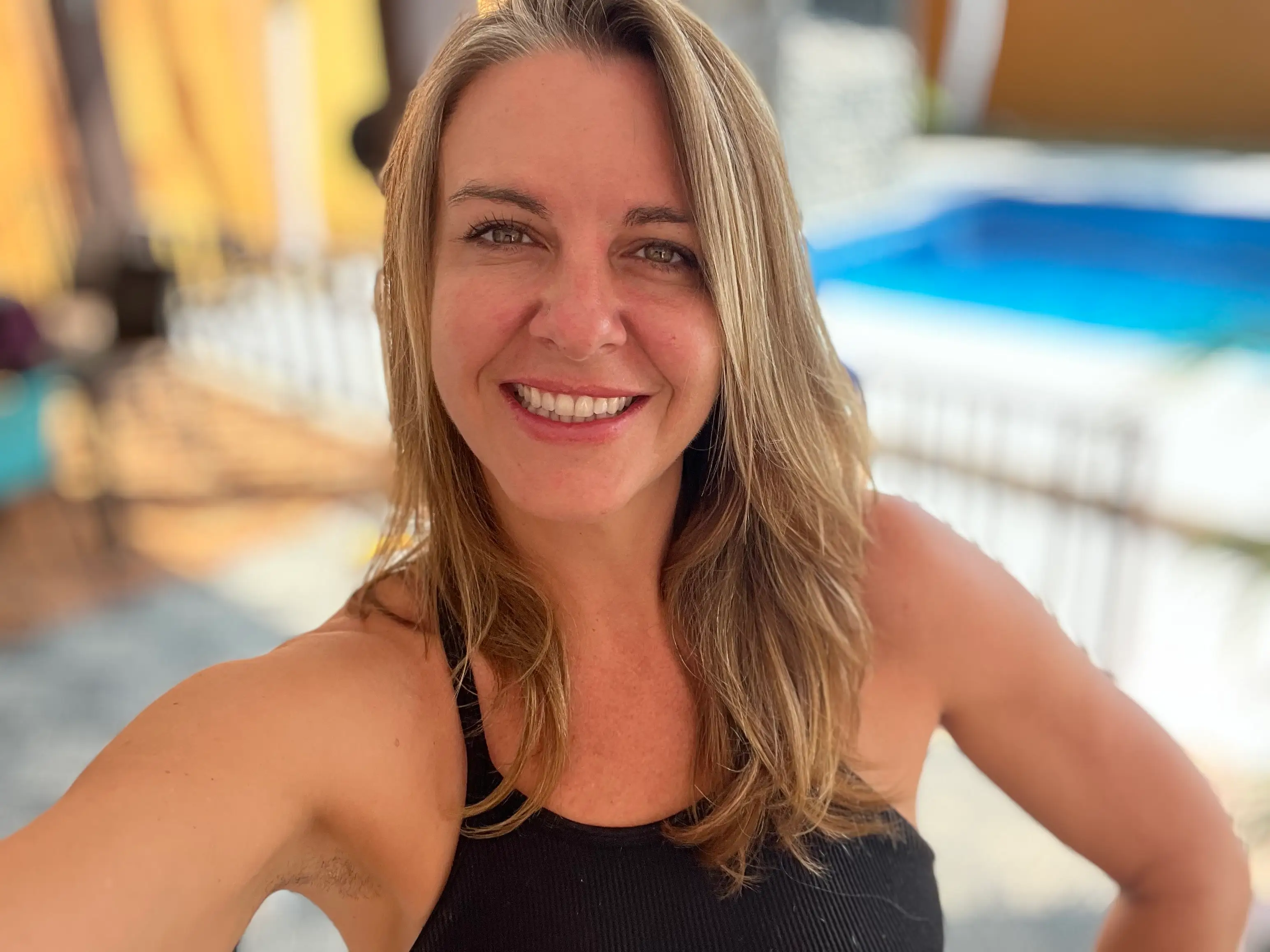 a woman takes a selfie in front of a pool