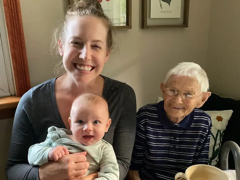 Woman holding baby next to grandmother
