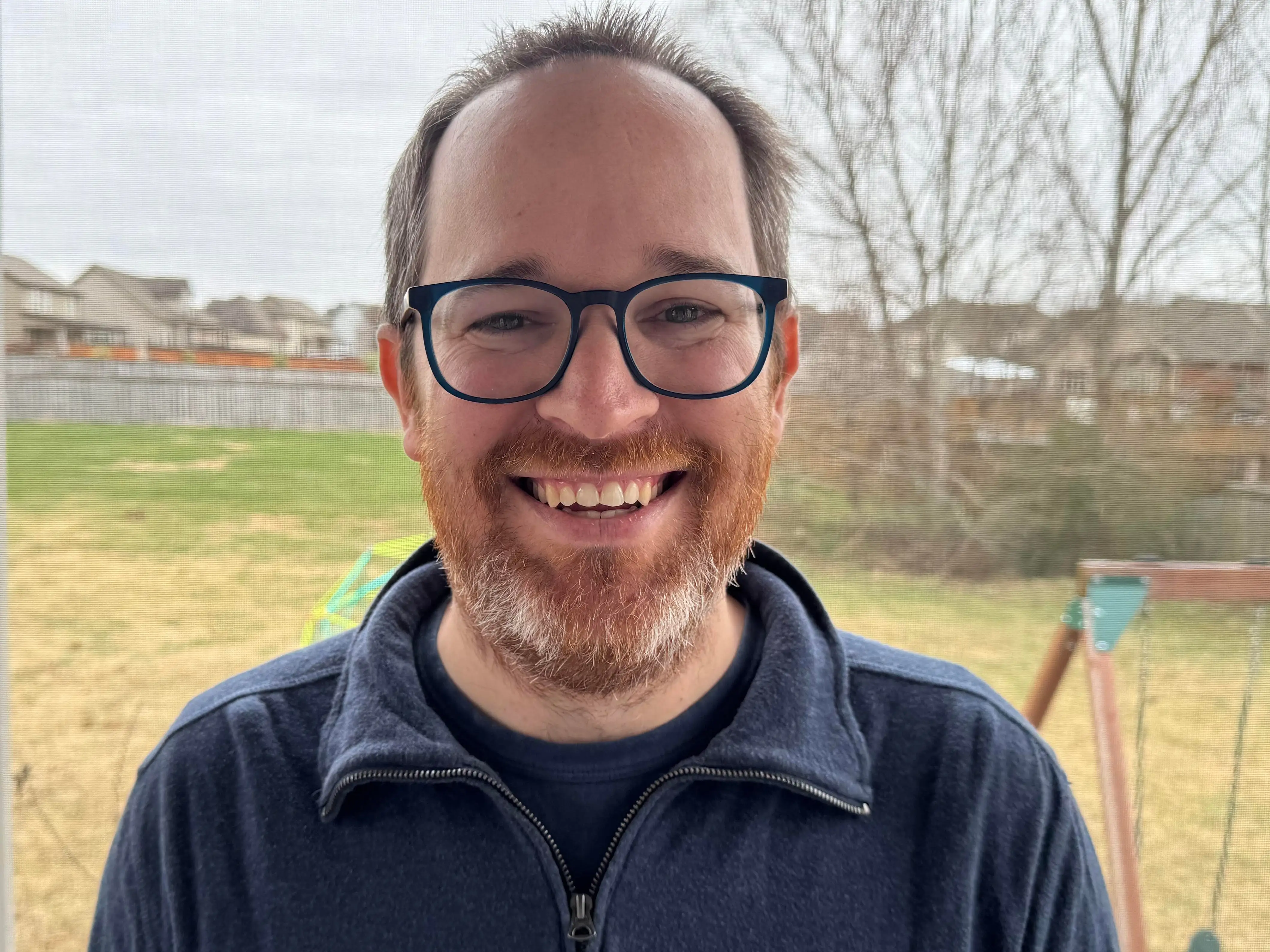 The author poses  with his yard in the background.