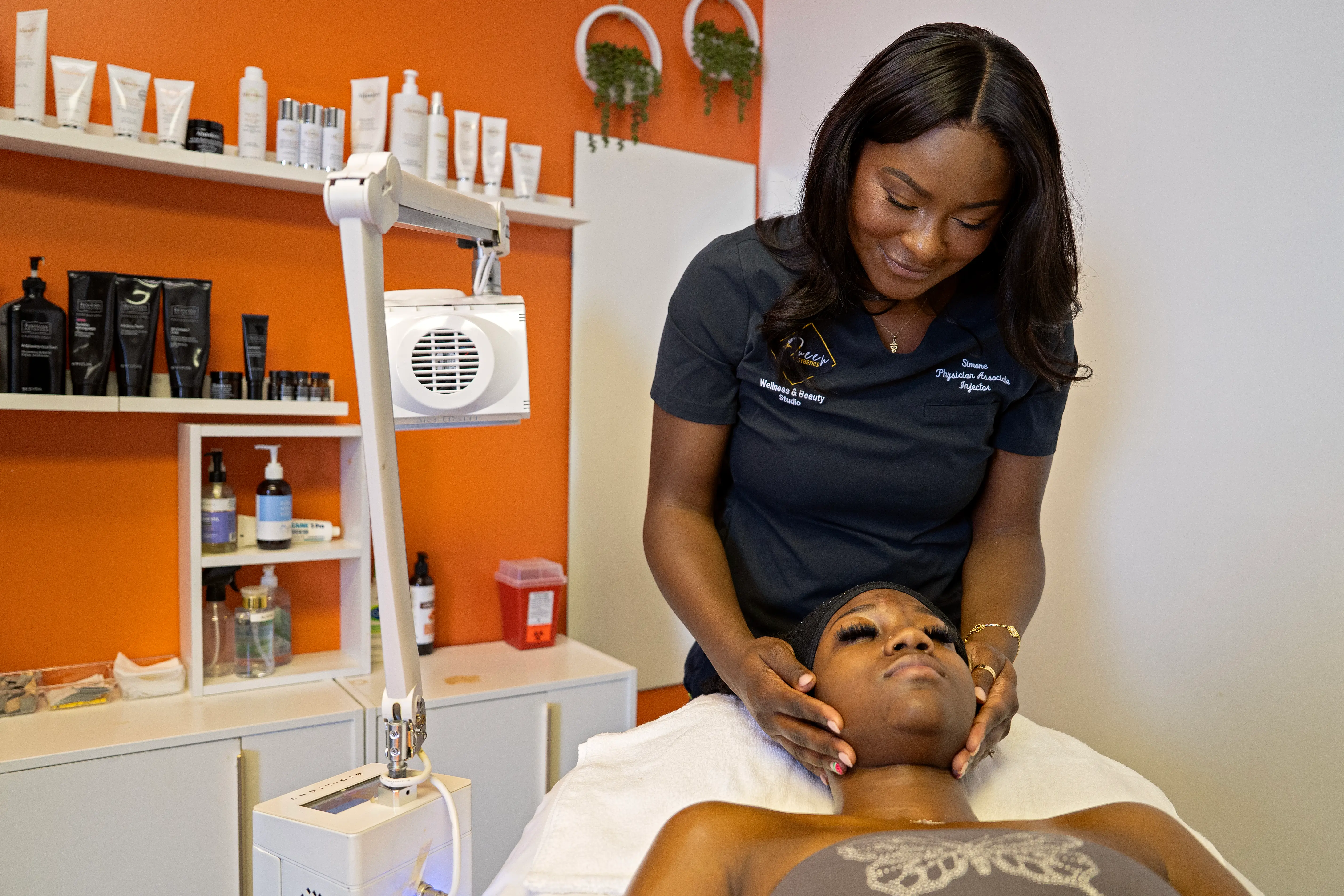 Simone, the founder of Queen Aesthetics, performs a facial on a client.