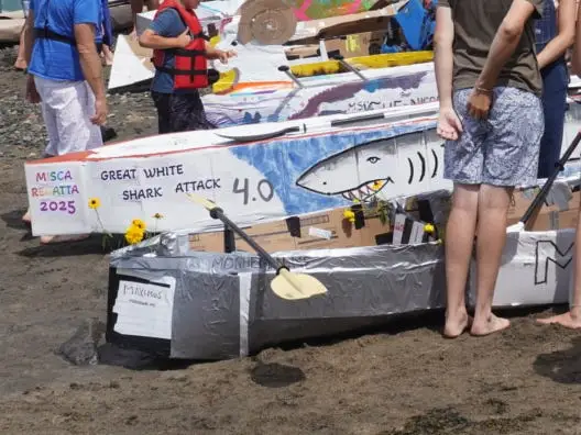 Elaborate cardboard boats on a beach.