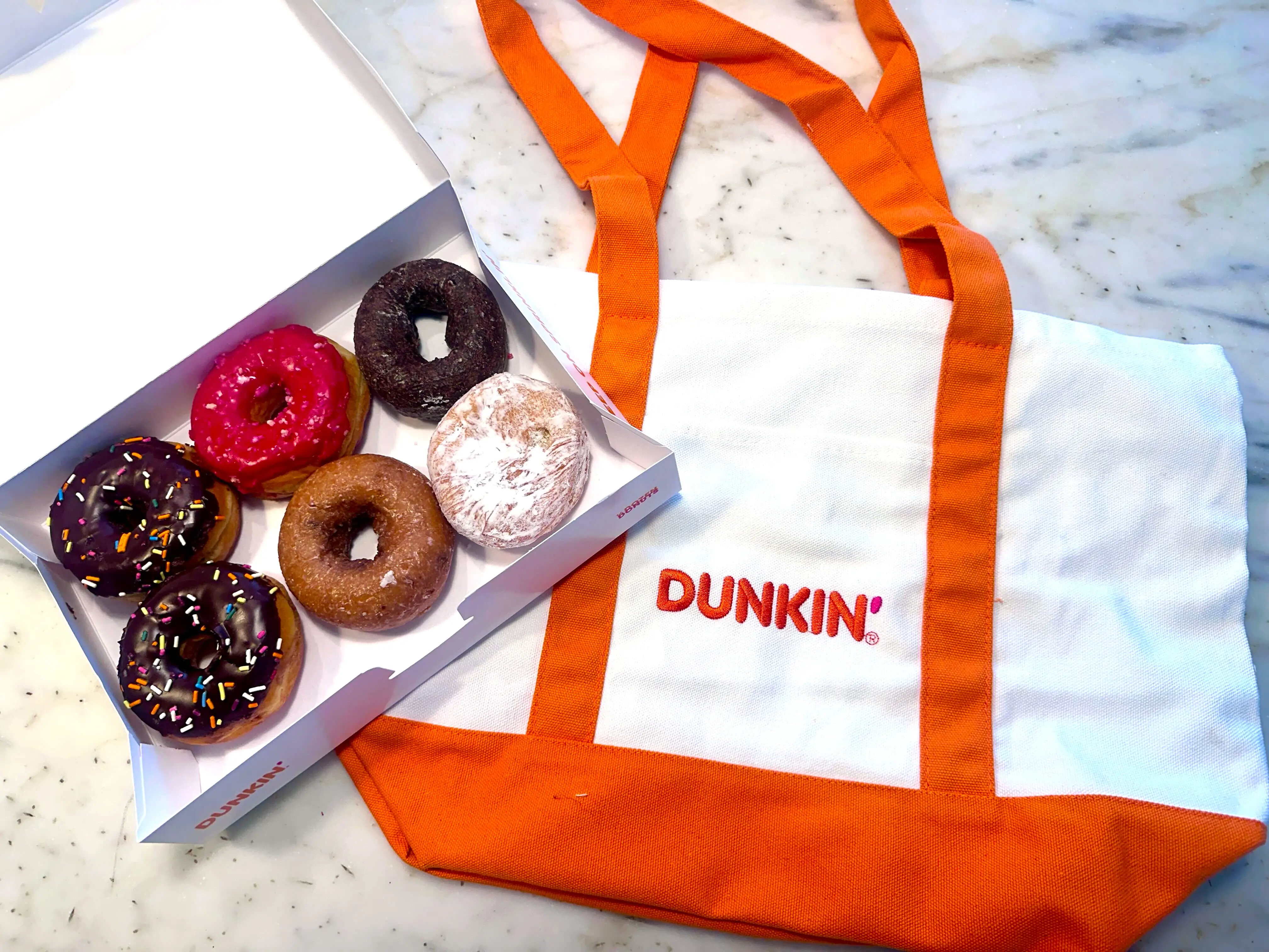 Dunkin' tote bag next to six donuts.
