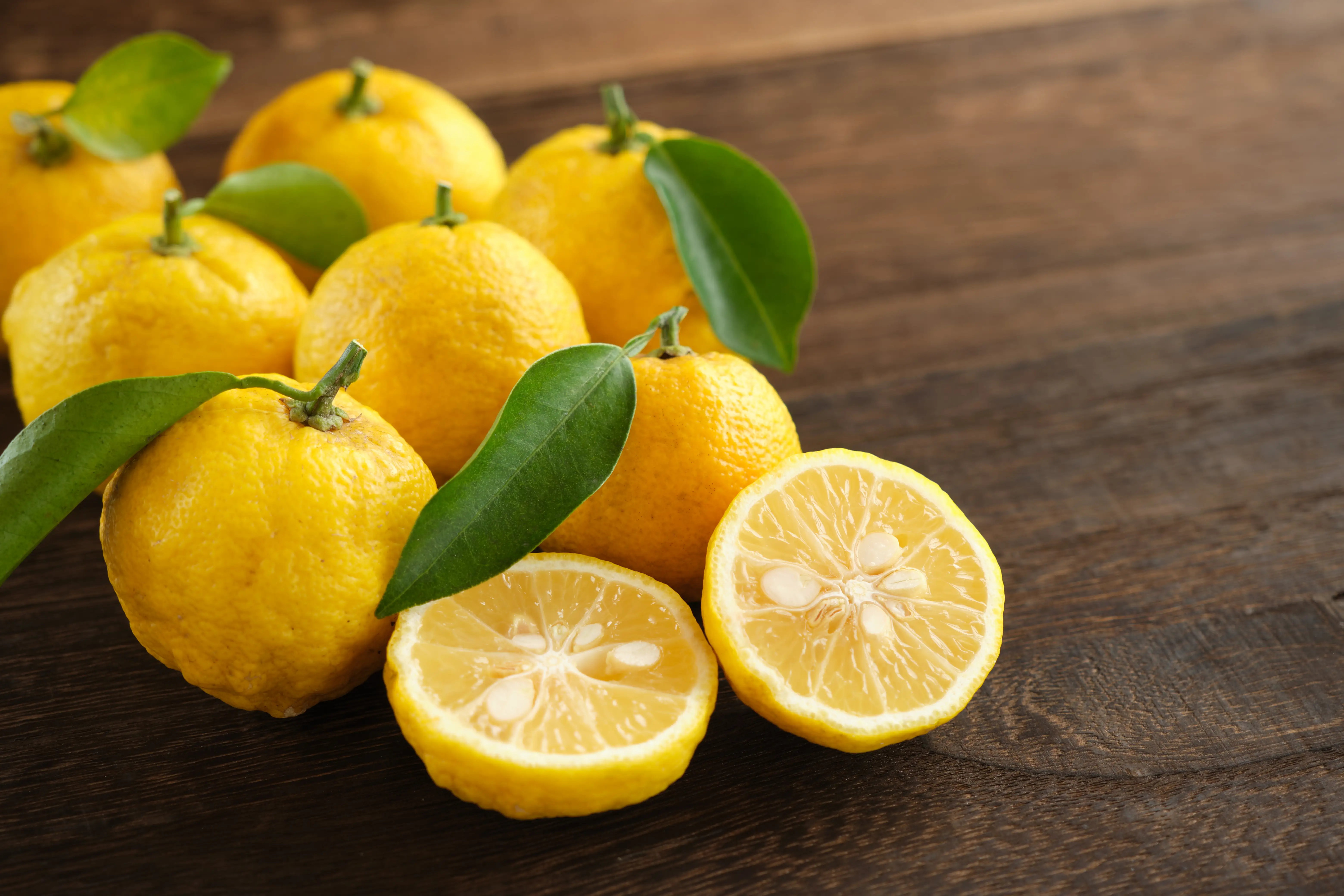 Yuzu fruits on a wood-grain table.