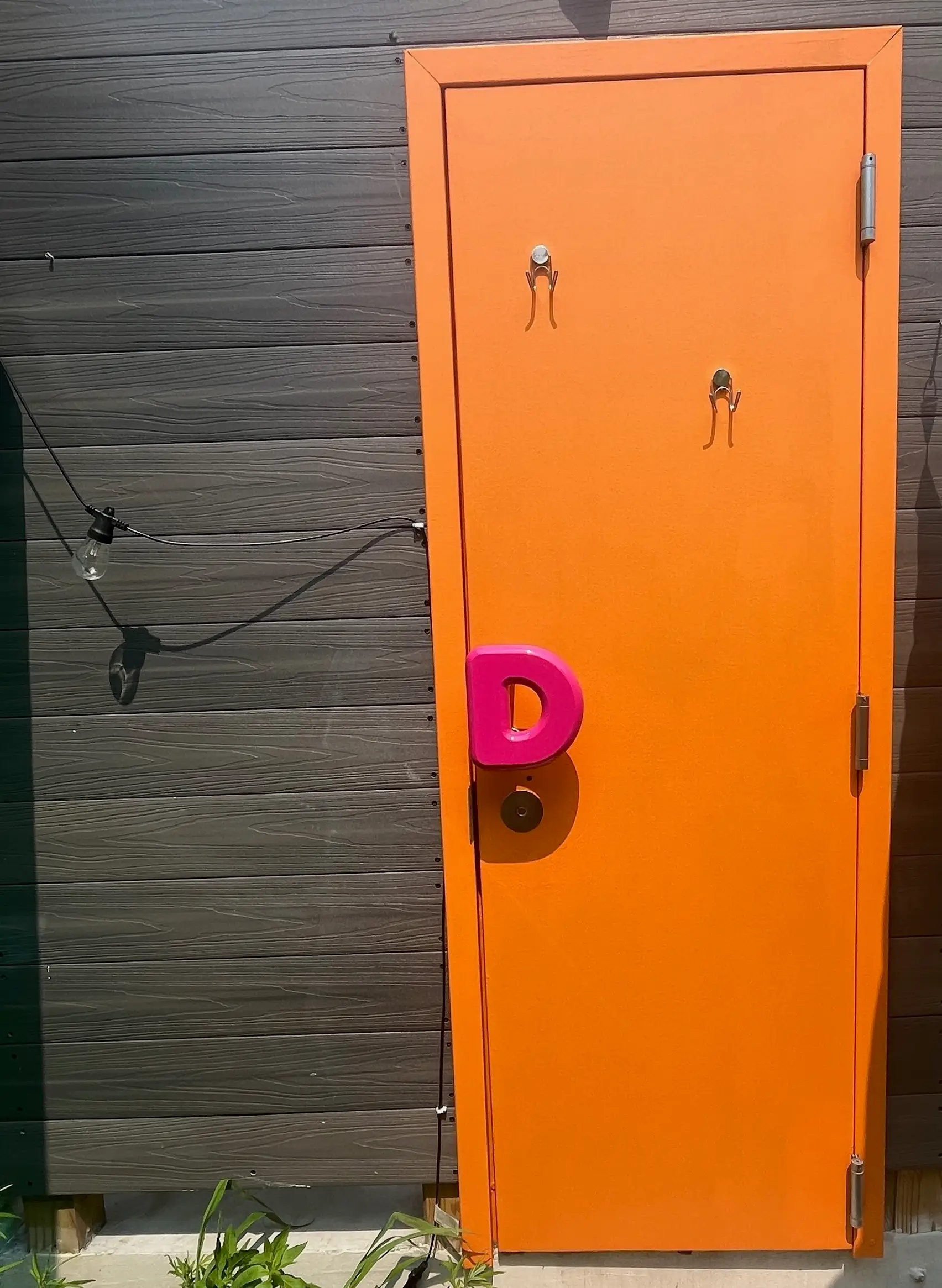 An orange door with a pink Dunkin'