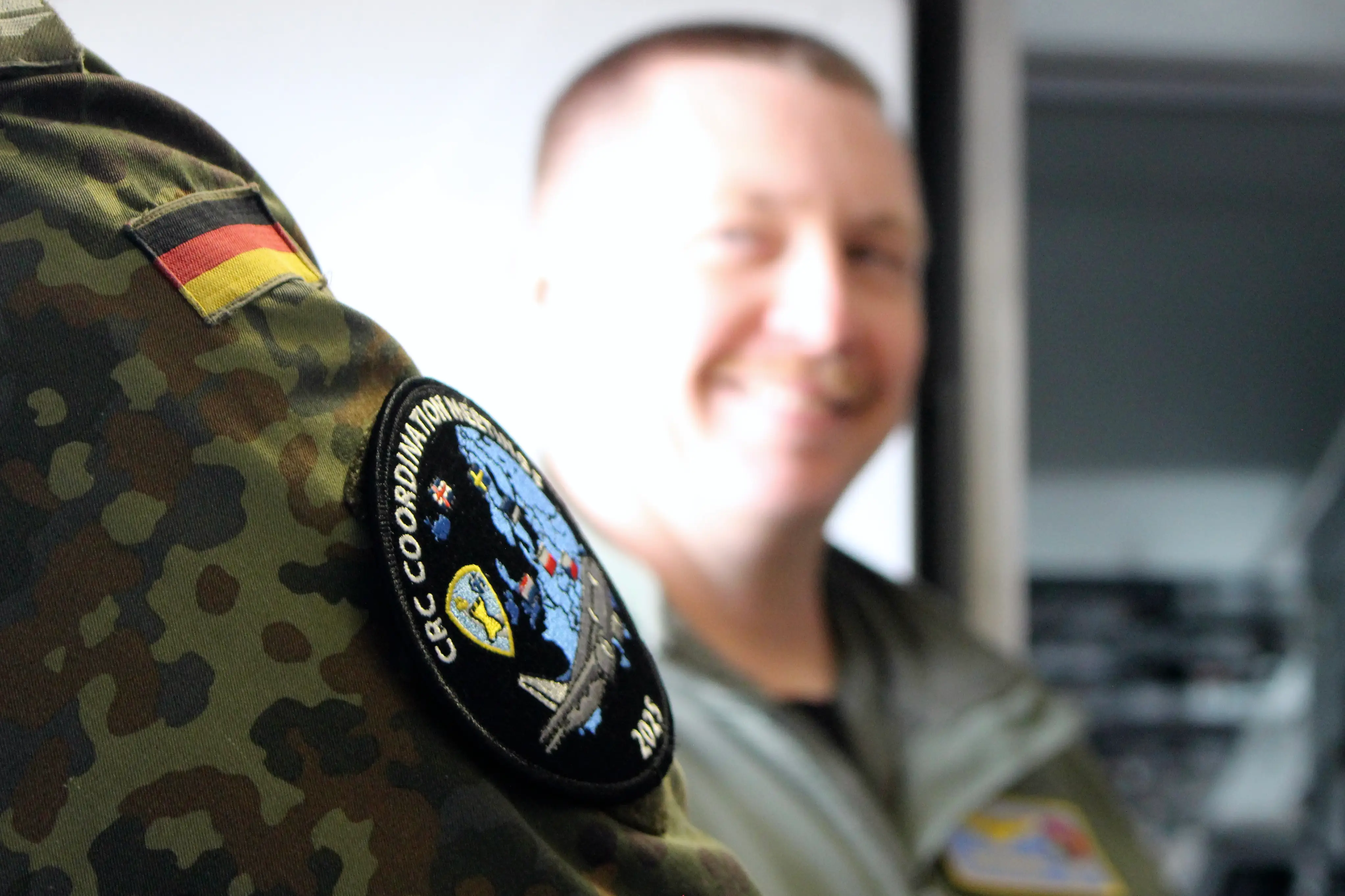 A member of the Combined Air Operations Centre Uedem wears a patch inside a P-8A Poseidon maritime patrol aircraft.
