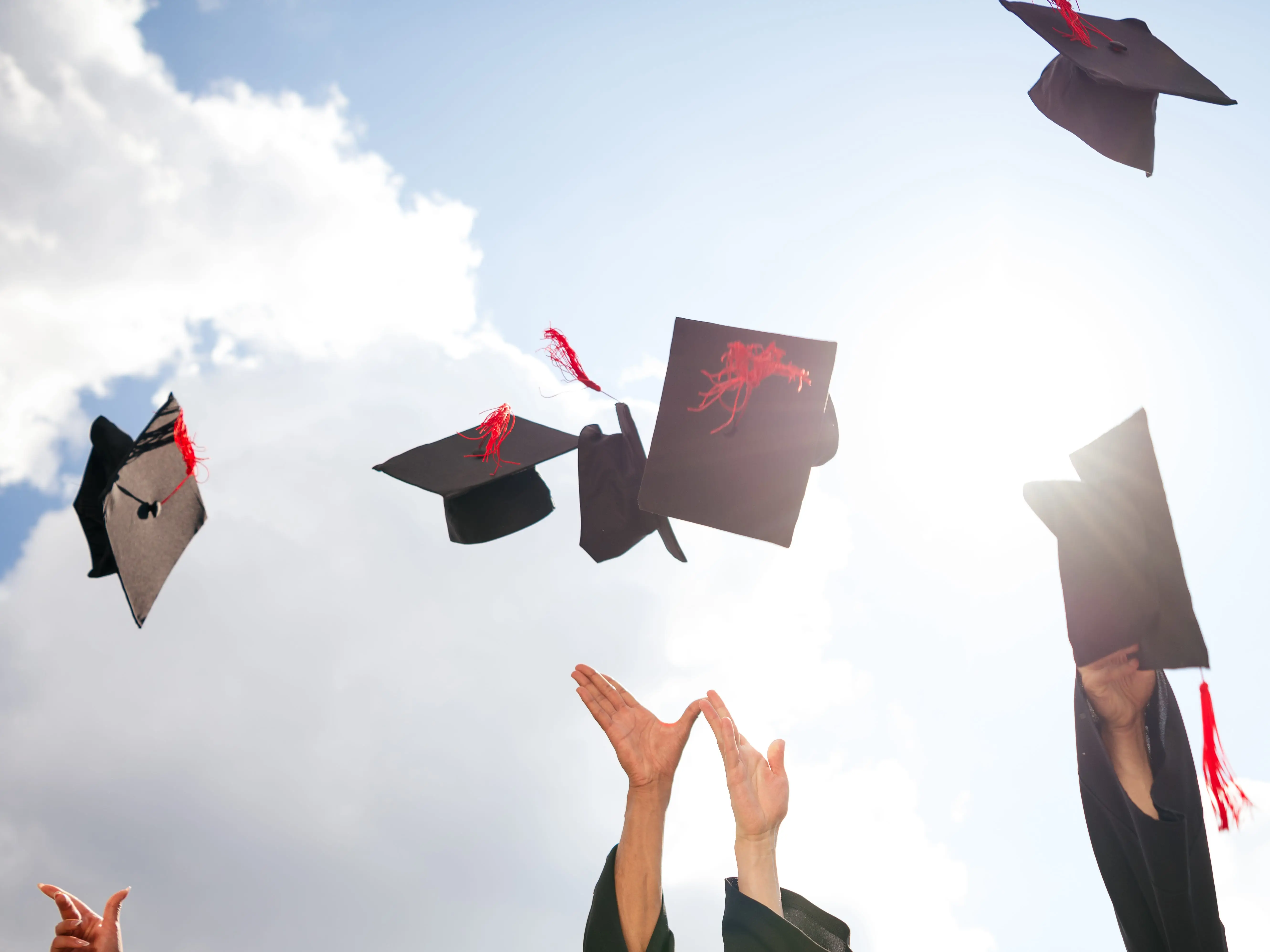 People throwing graduation caps