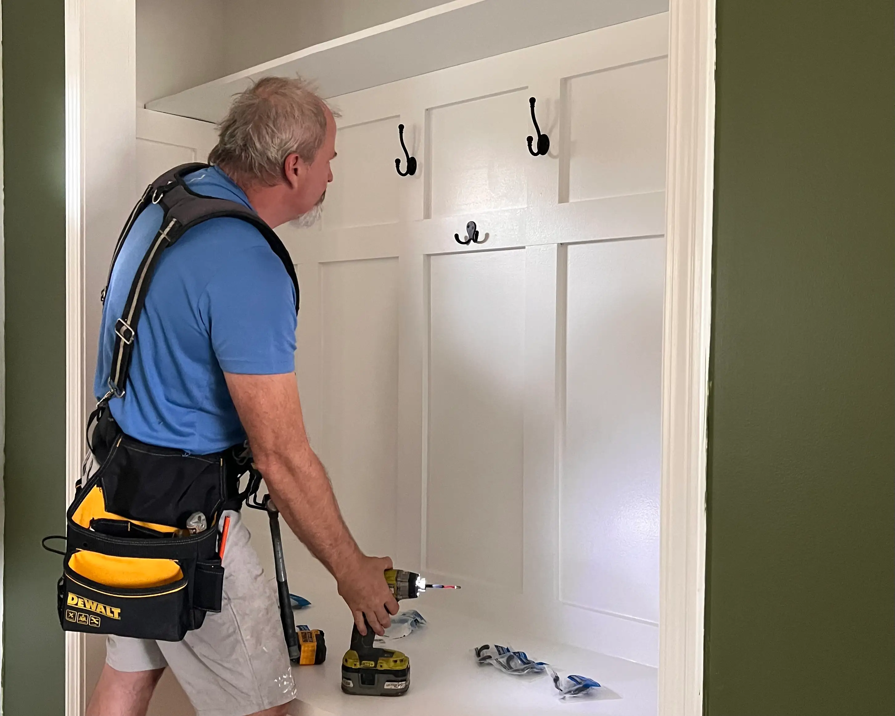 Man hanging hooks on shelves