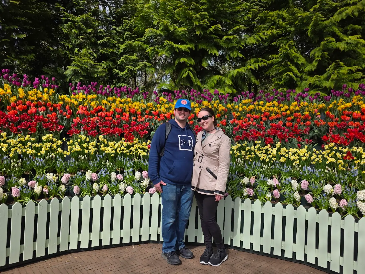 The writer and her partner standing in front of tulips in Amsterdam.