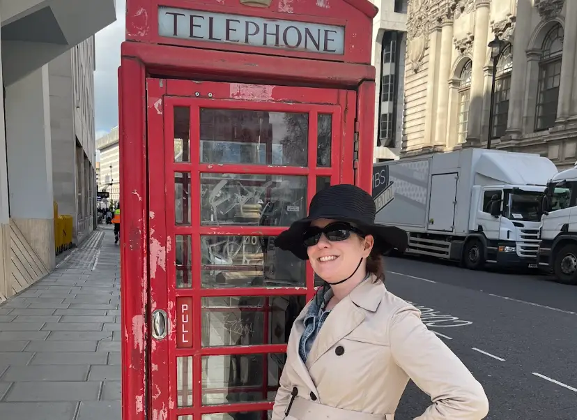 The writer standing in front of a red telephone booth in London.