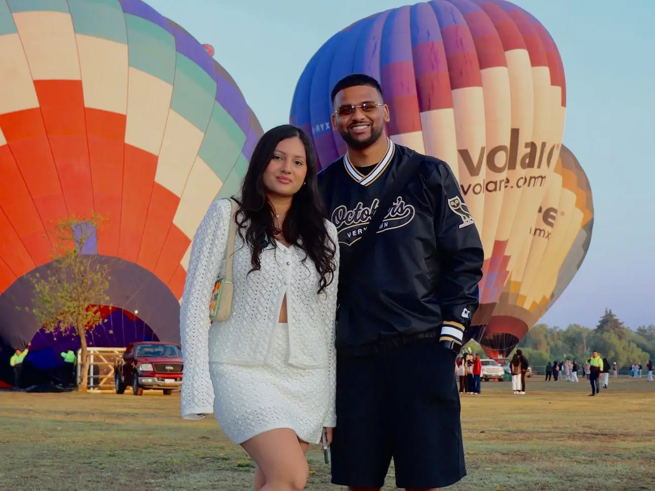 Shriya Agnihotri and her partner, Nithusan, stand in front of hot-air balloons.