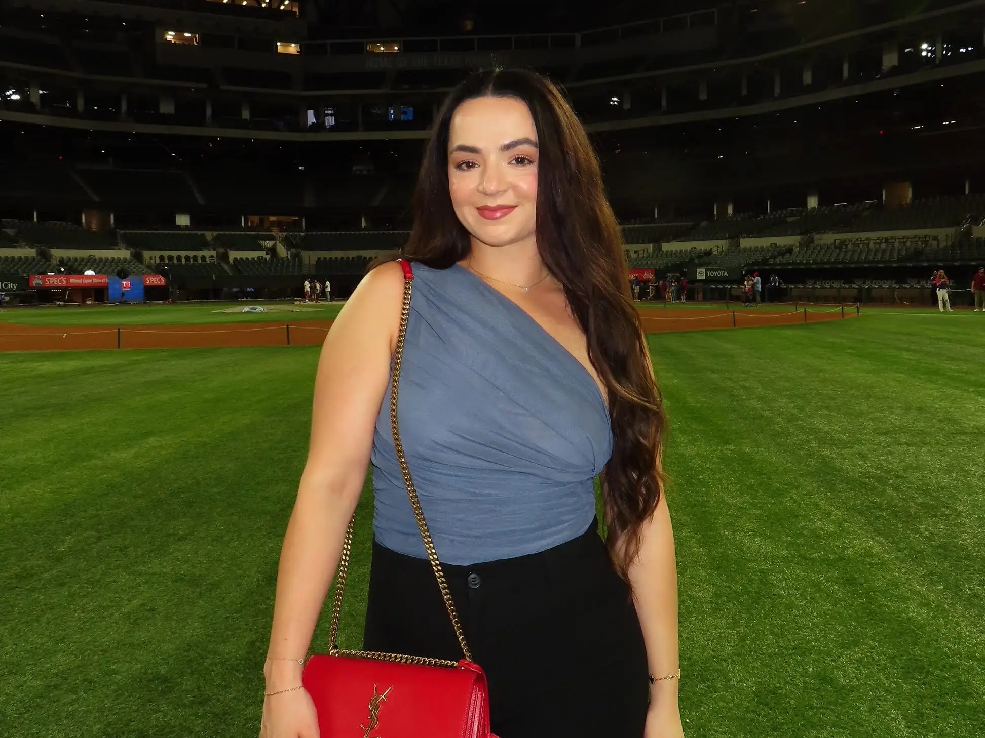 Travel content creator Vanessa Jimenez stands on a sports pitch.