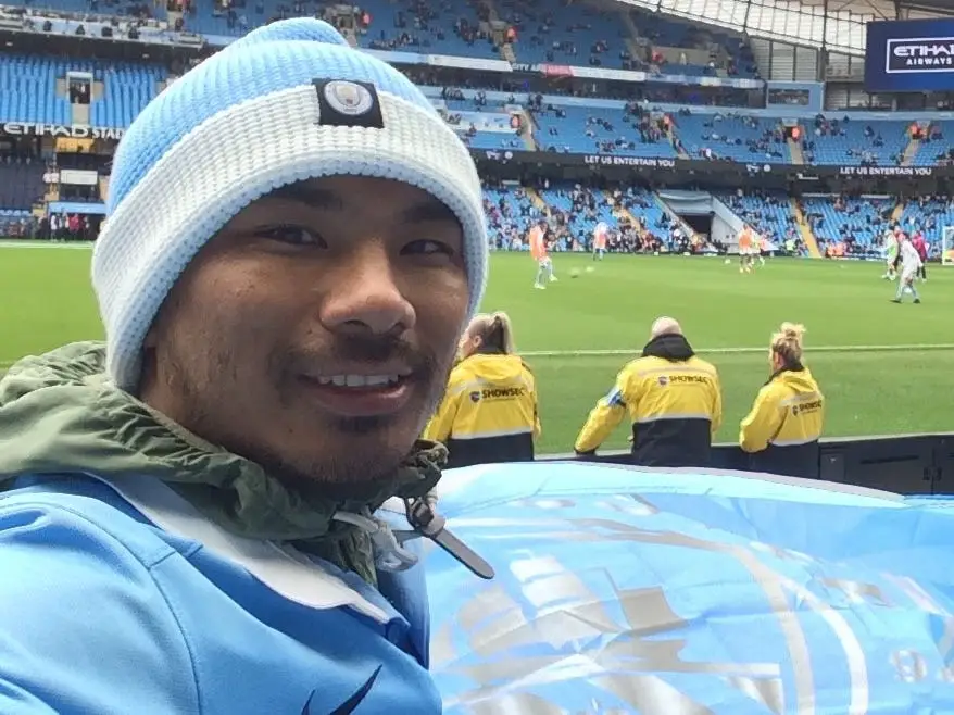 Worchihan in blue hat and jacket at a soccer matach.
