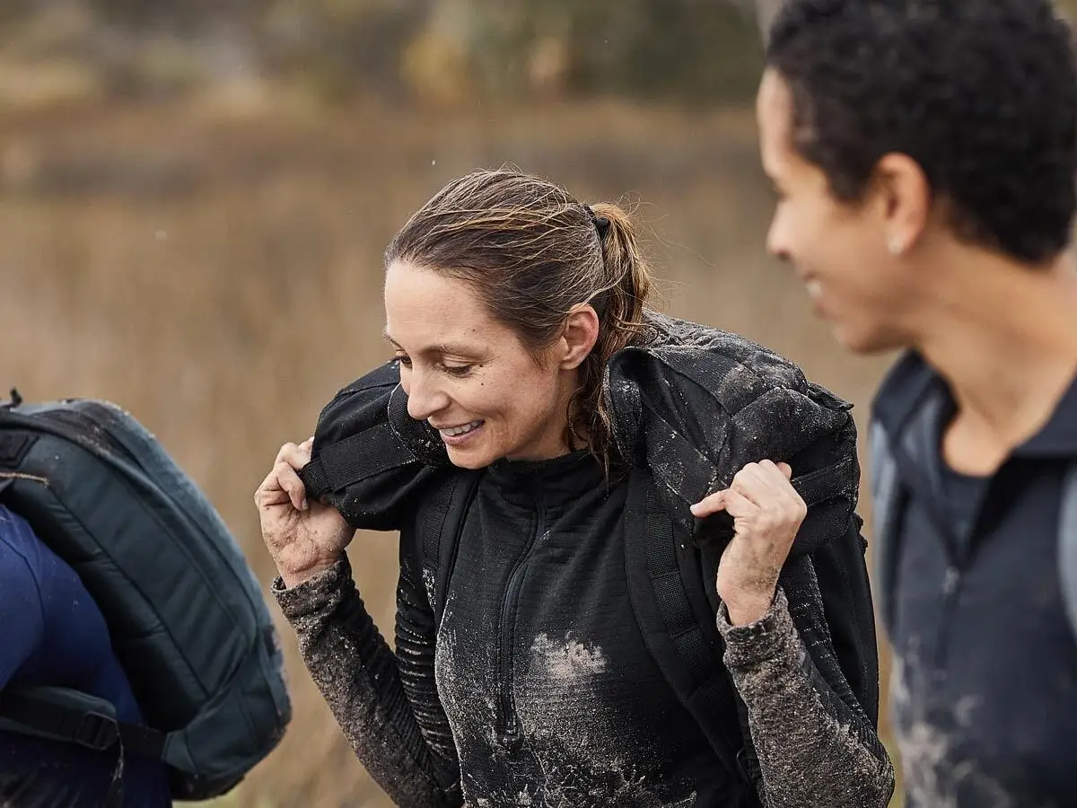 a woman carrying a weighted pack outdoors