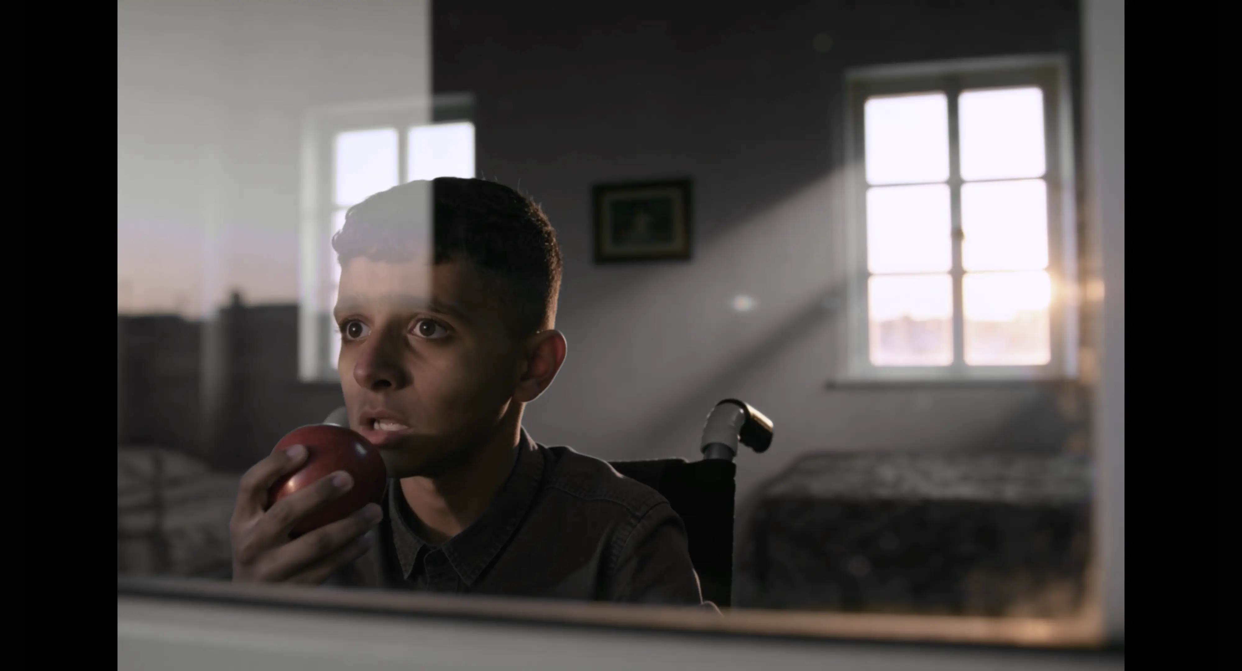 A still from an AI-made film showing a boy holding an apple.