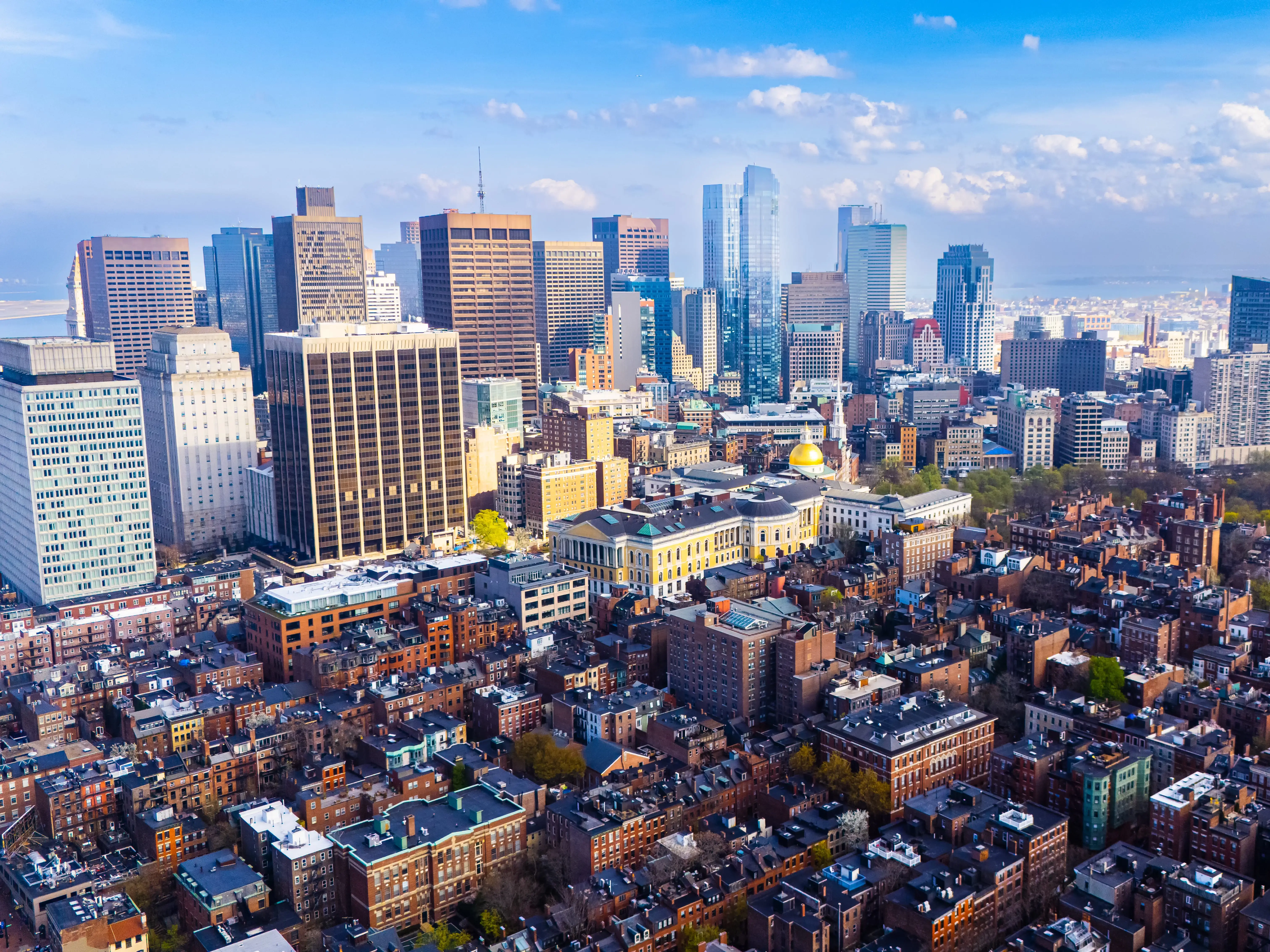 Orange brick houses along stunning skyscrapers. Varied scenery of Boston, Massachusetts, USA. Aerial view.
