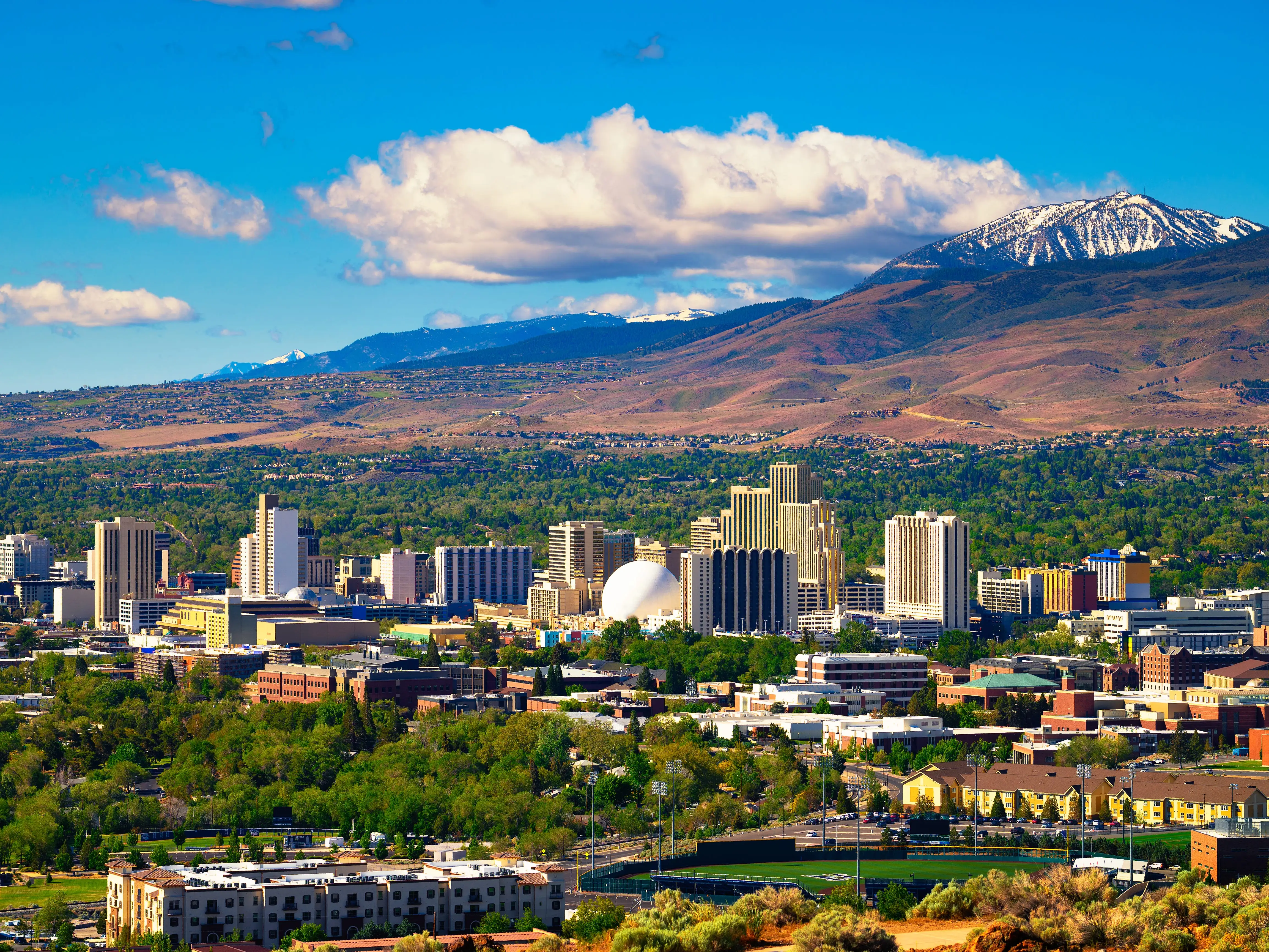 Downtown Reno skyline, Nevada, with hotels, casinos and the surrounding High Eastern Sierra foothills