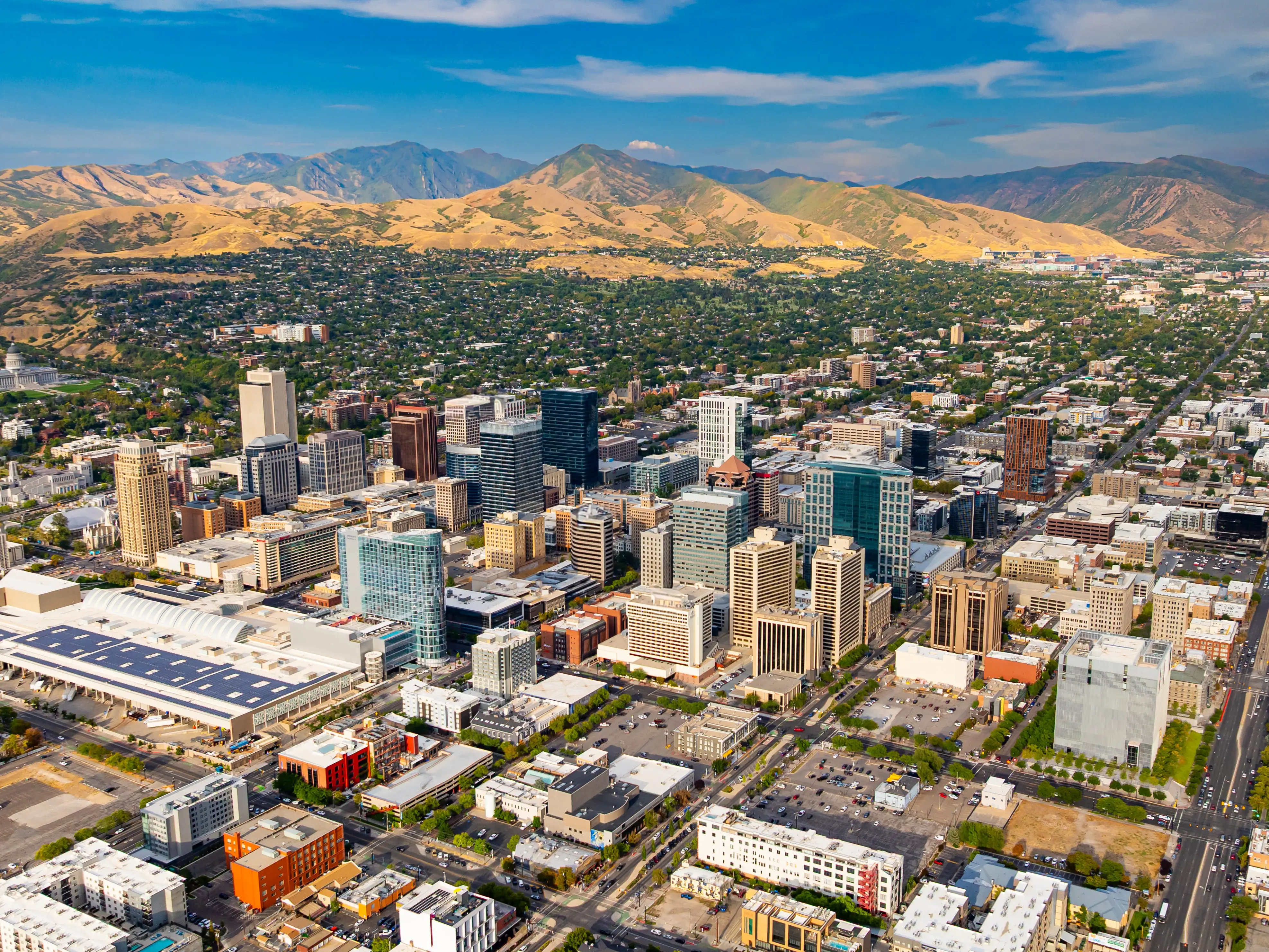 Downtown of Salt Lake City, Utah, USA. Green residential area scattered at backdrop at the foot of the mountains.