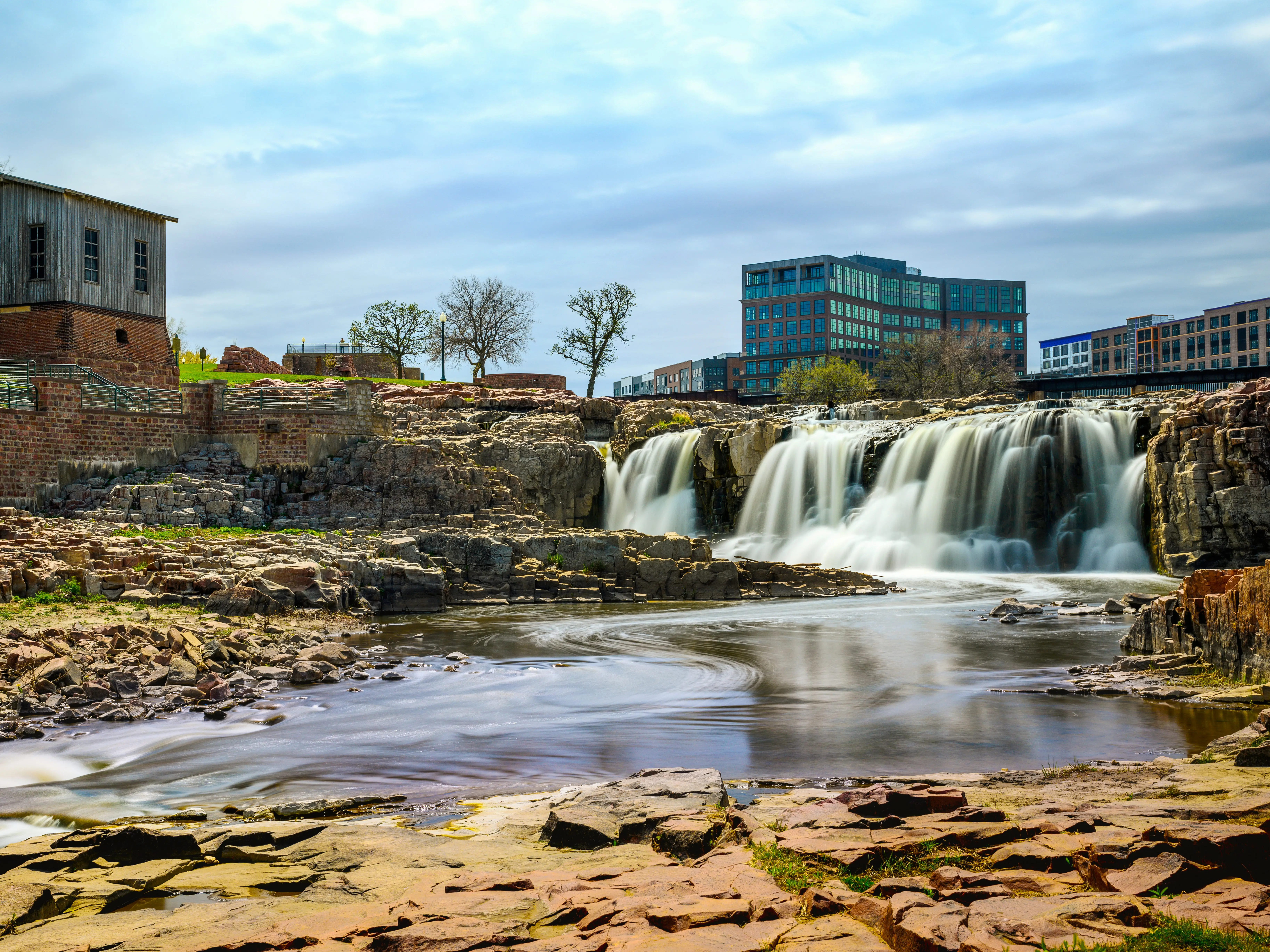 Sioux Falls City Spring Landscape at the Falls Park in Sioux Falls, South Dakota, USA, silky water falling over quartzite and pipestone rock formations in the Big Sioux River