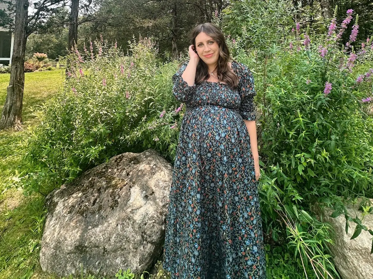 The author poses while pregnant with her second child in her backyard.