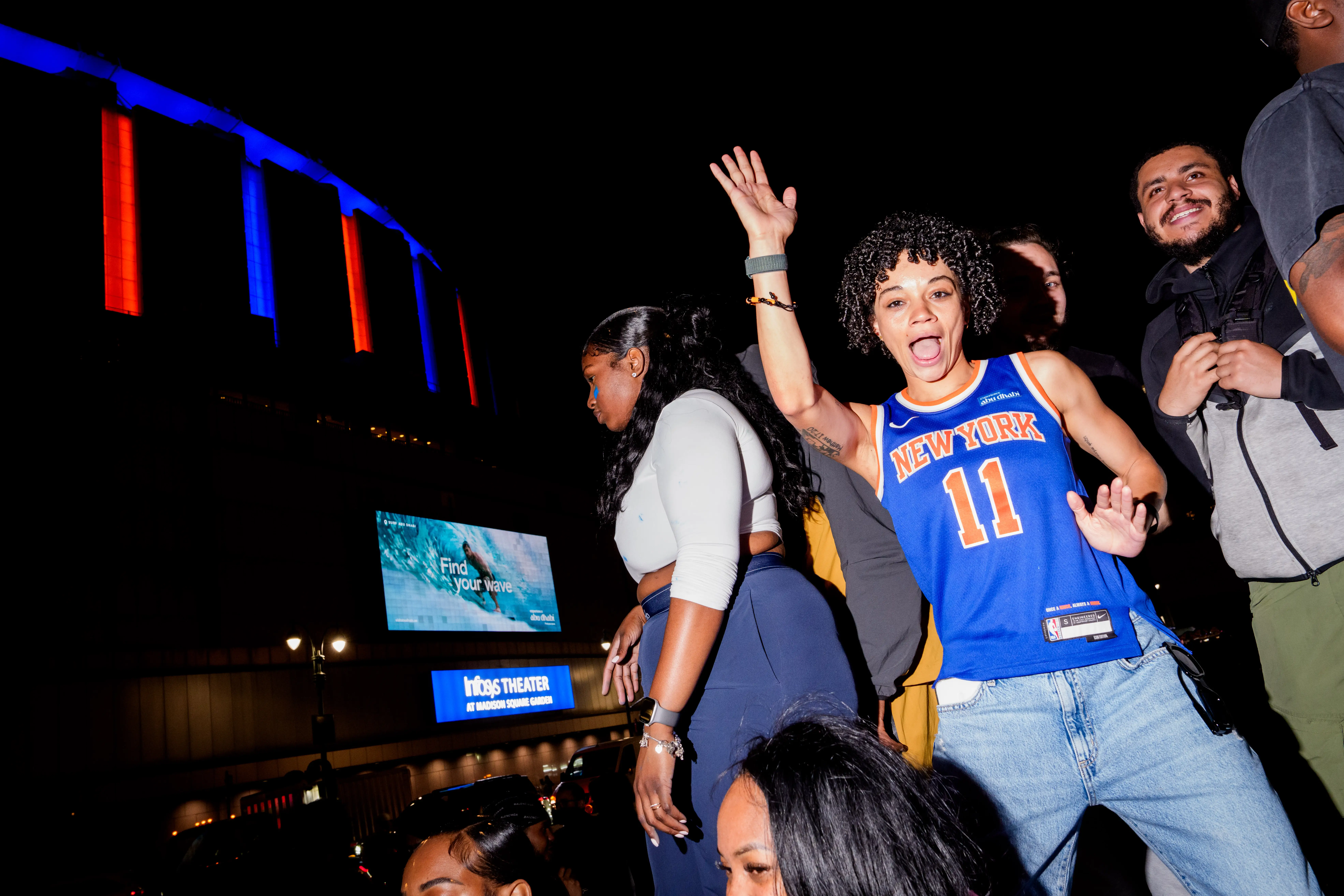 A New York Knicks fan in a Jalen Brunson jersey celebrates outside Madison Square Garden.